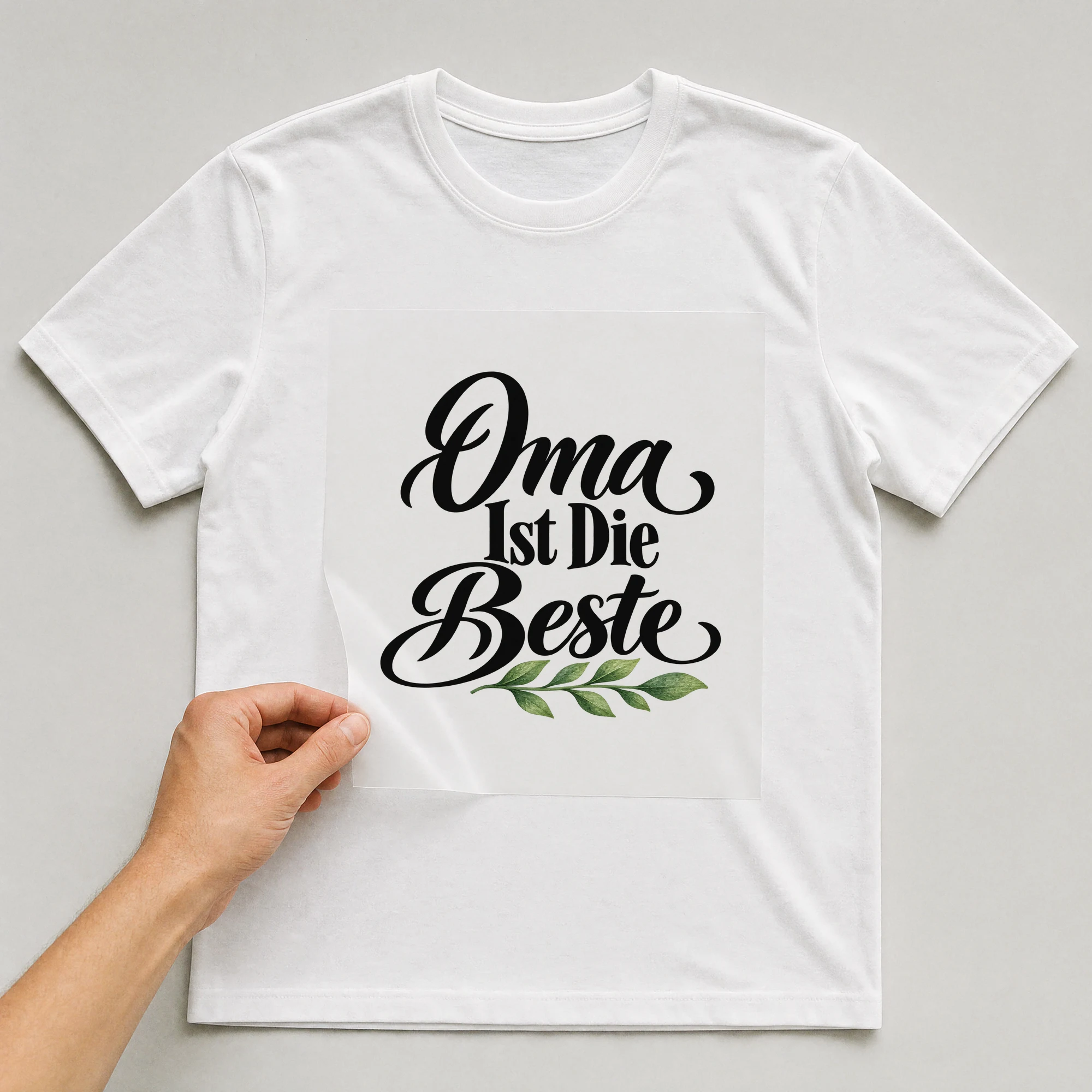 Bügelbild „Oma ist die beste“ auf weißem T-Shirt, Folie wird aufgelegt