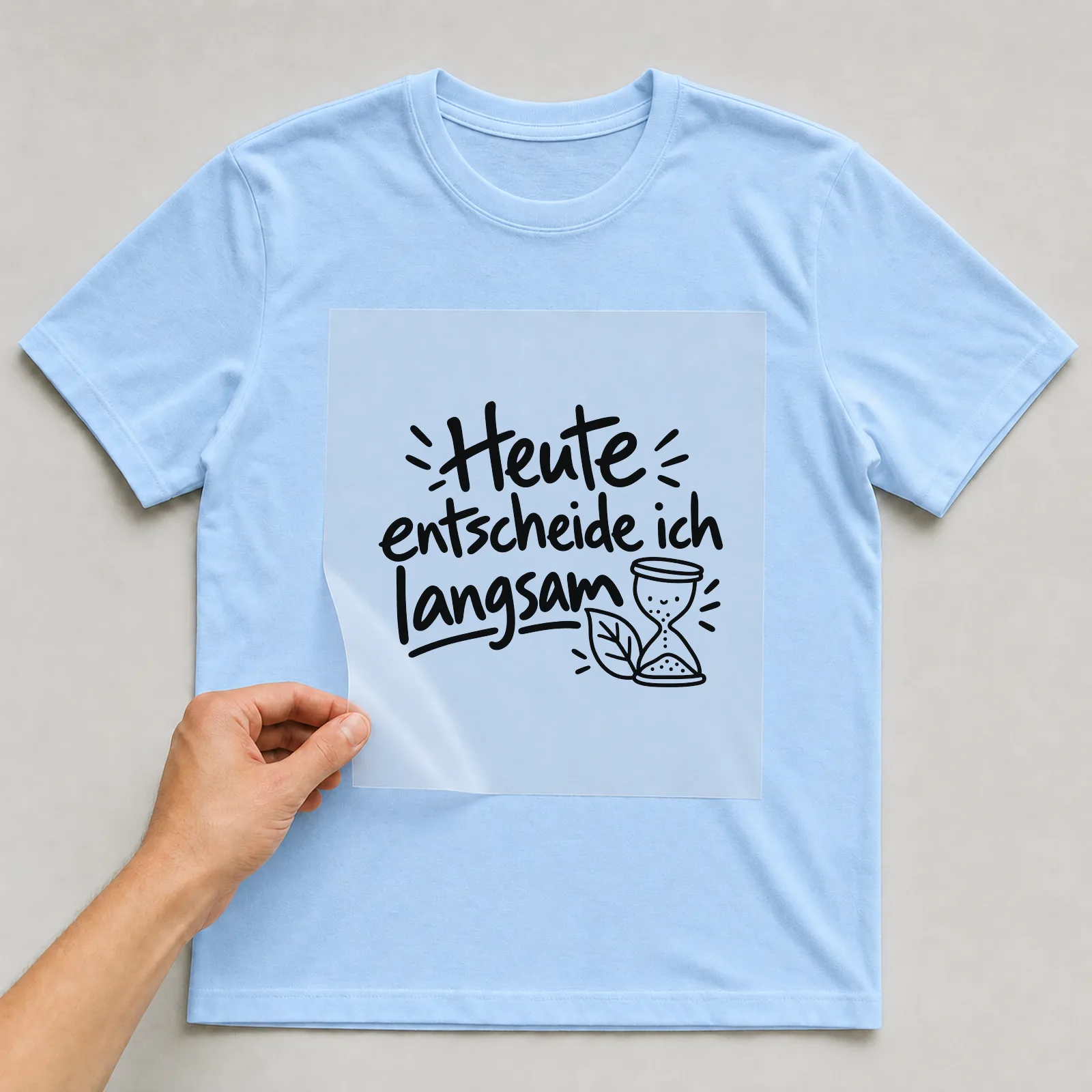 Bügelbild „Heute entscheide ich langsam“ auf hellblauem T-Shirt, Folie wird aufgelegt