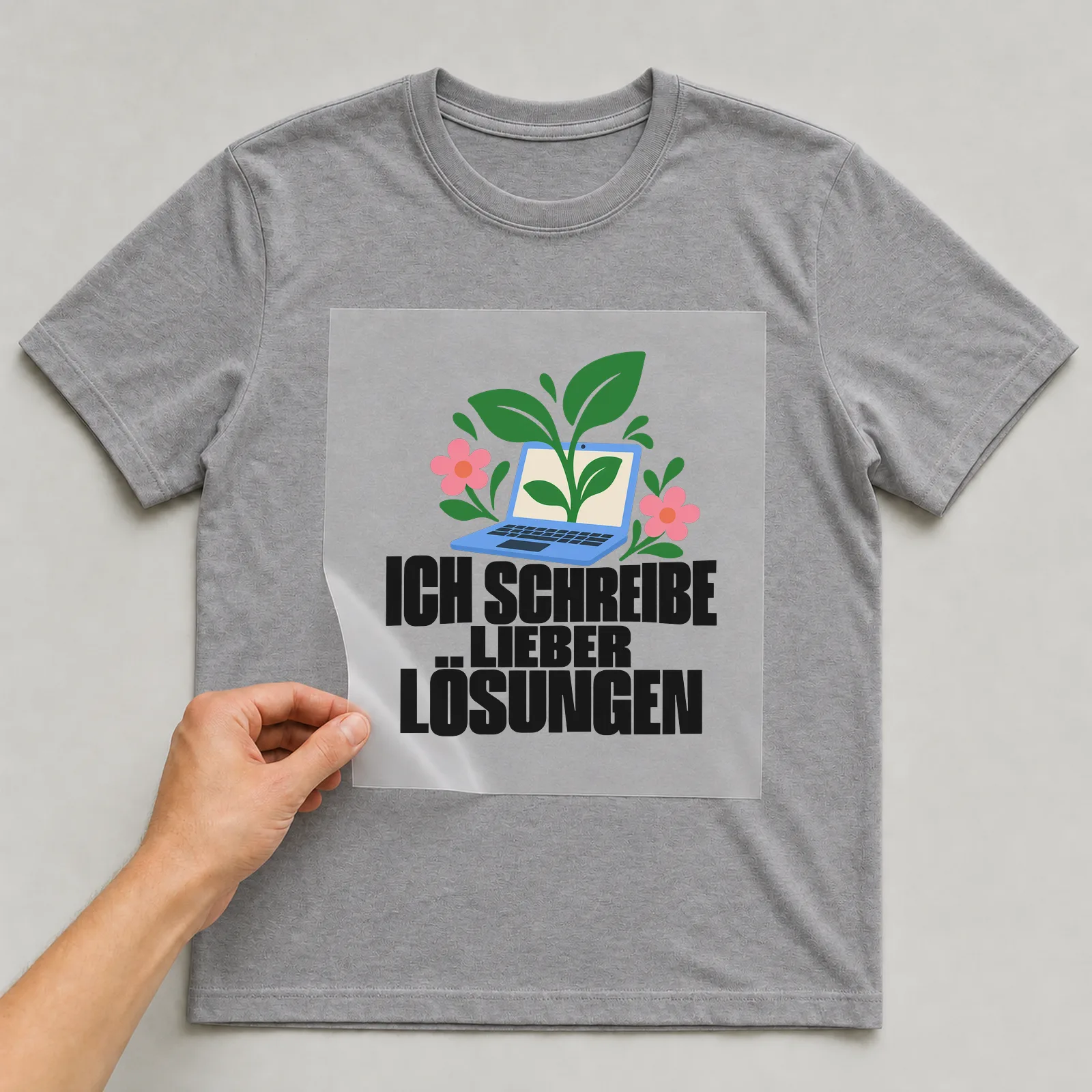 Bügelbild „Ich schreibe lieber Lösungen“ auf grauem T-Shirt, Folie wird aufgelegt
