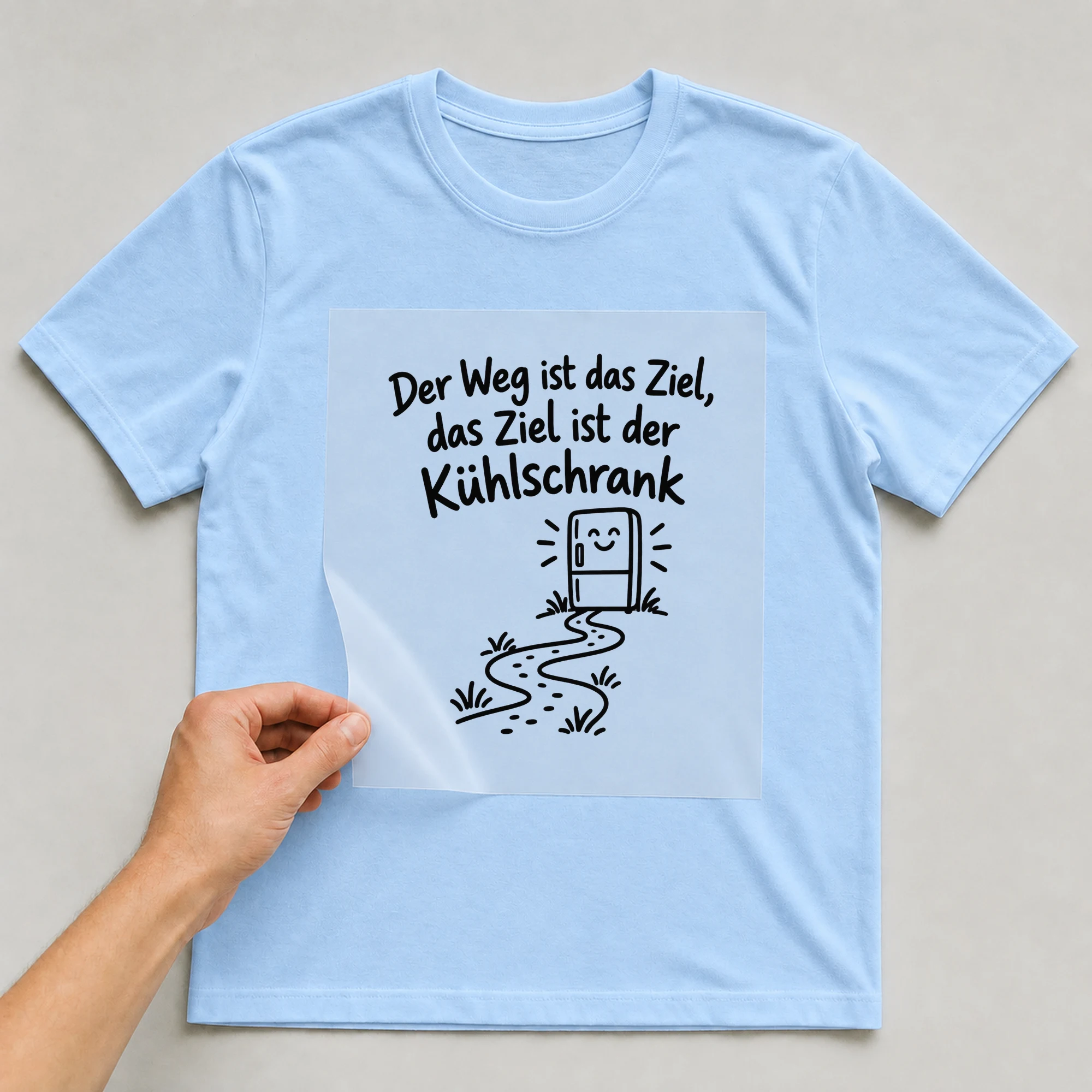 Bügelbild „Der Weg ist das Ziel, das Ziel ist der Kühlschrank“ auf babyblauem T-Shirt, Folie wird aufgelegt