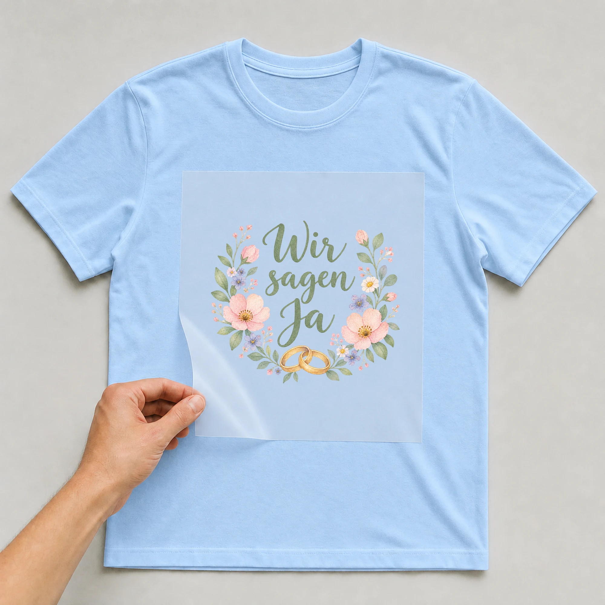 Bügelbild „Wir sagen ja“ auf babyblauem T-Shirt, Folie wird aufgelegt