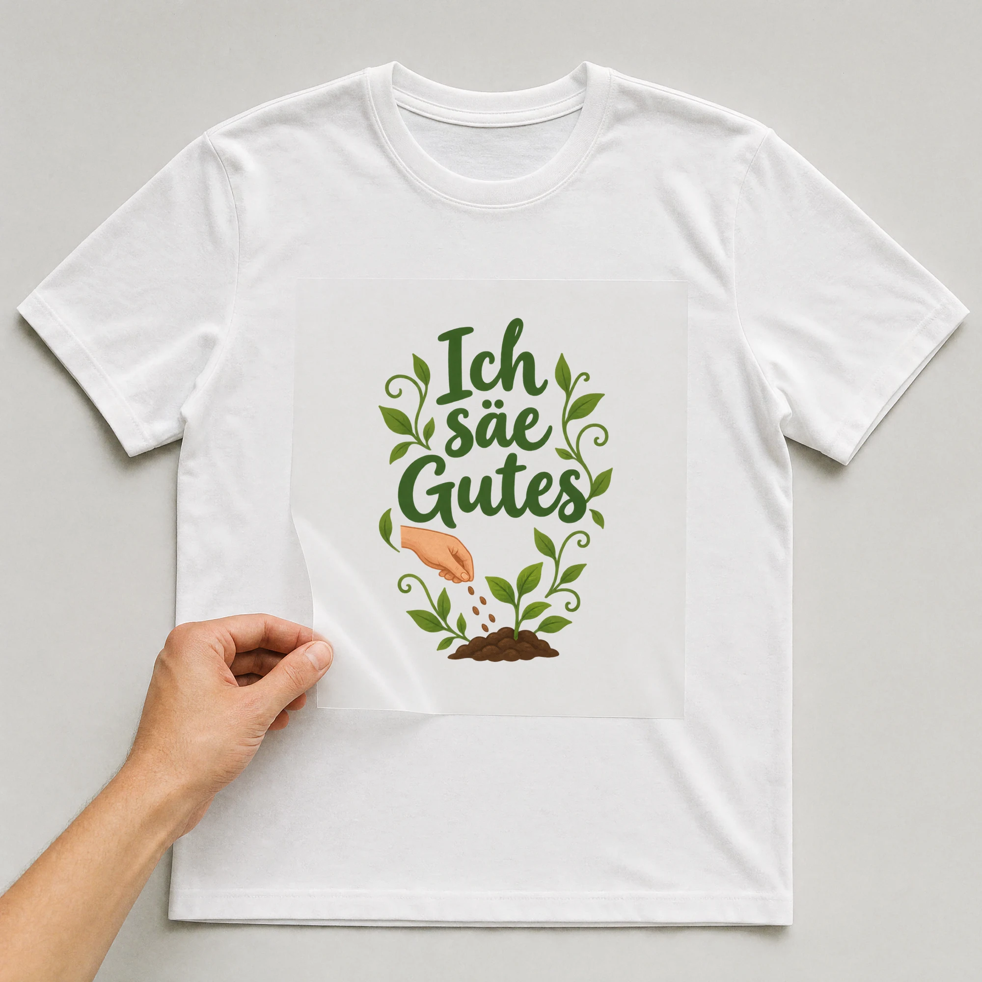 Bügelbild „Ich säe Gutes“ auf weißem T-Shirt, Folie wird aufgelegt