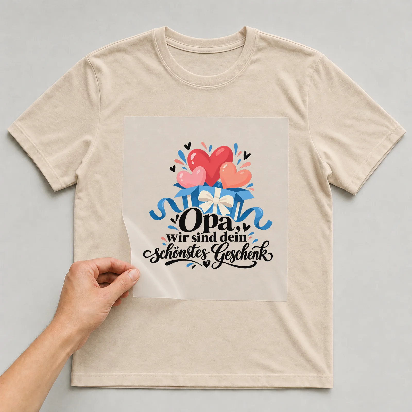 Bügelbild „Opa, wir sind dein schönstes Geschenk“ auf beigem T-Shirt, Folie wird aufgelegt
