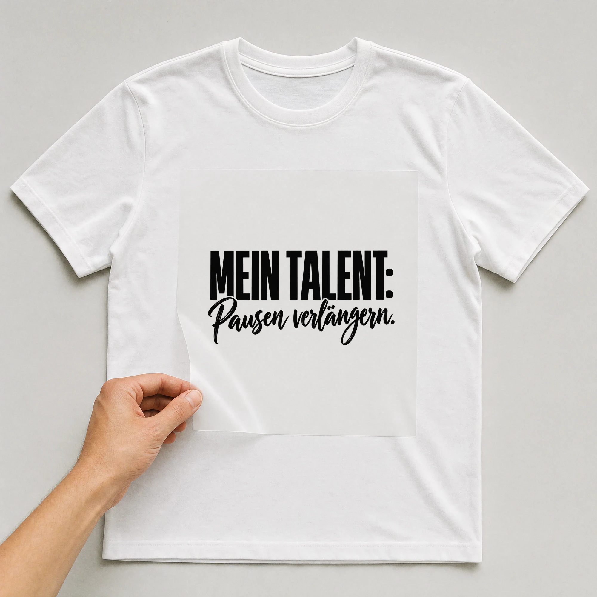Bügelbild „Mein Talent: Pausen verlängern.“ auf weißem T-Shirt, Folie wird aufgelegt