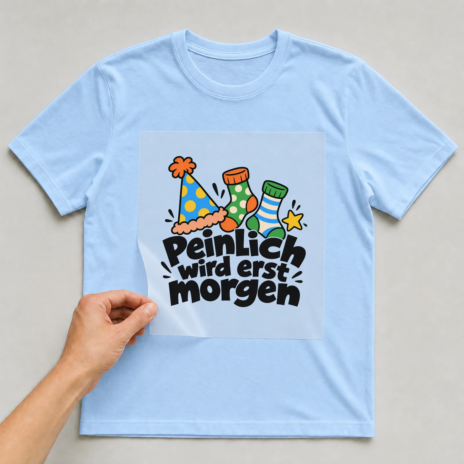 Bügelbild „Peinlich wird erst morgen“ auf hellblauem T-Shirt, Folie wird aufgelegt