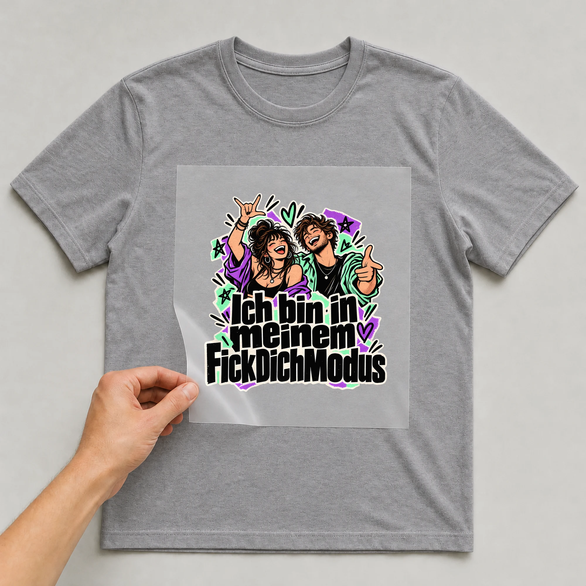 Bügelbild „Ich bin in meinem F*ckDichModus“ auf grauem T-Shirt, Folie wird aufgelegt