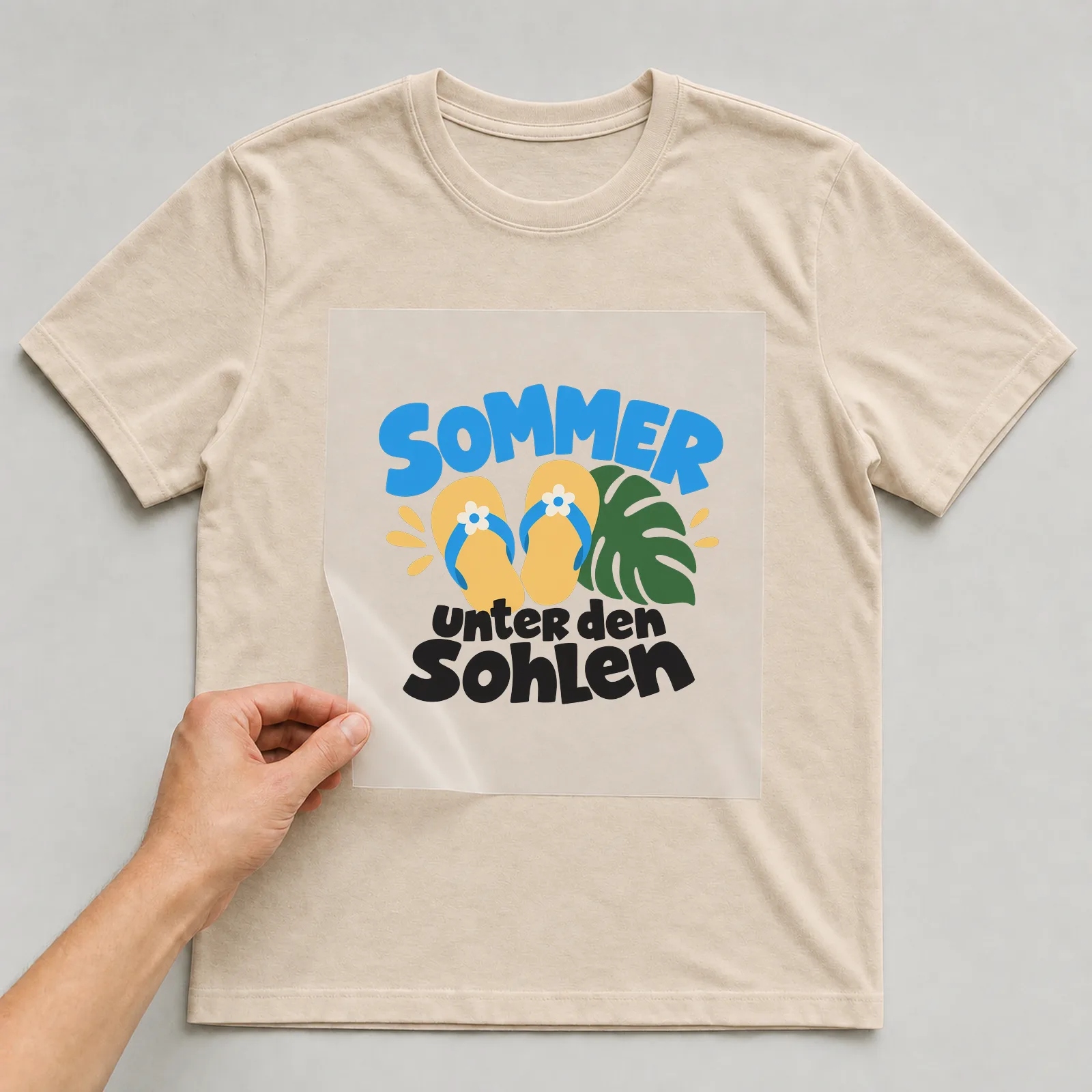 Bügelbild „Sommer unter den Sohlen“ auf beigem T-Shirt, Folie wird aufgelegt