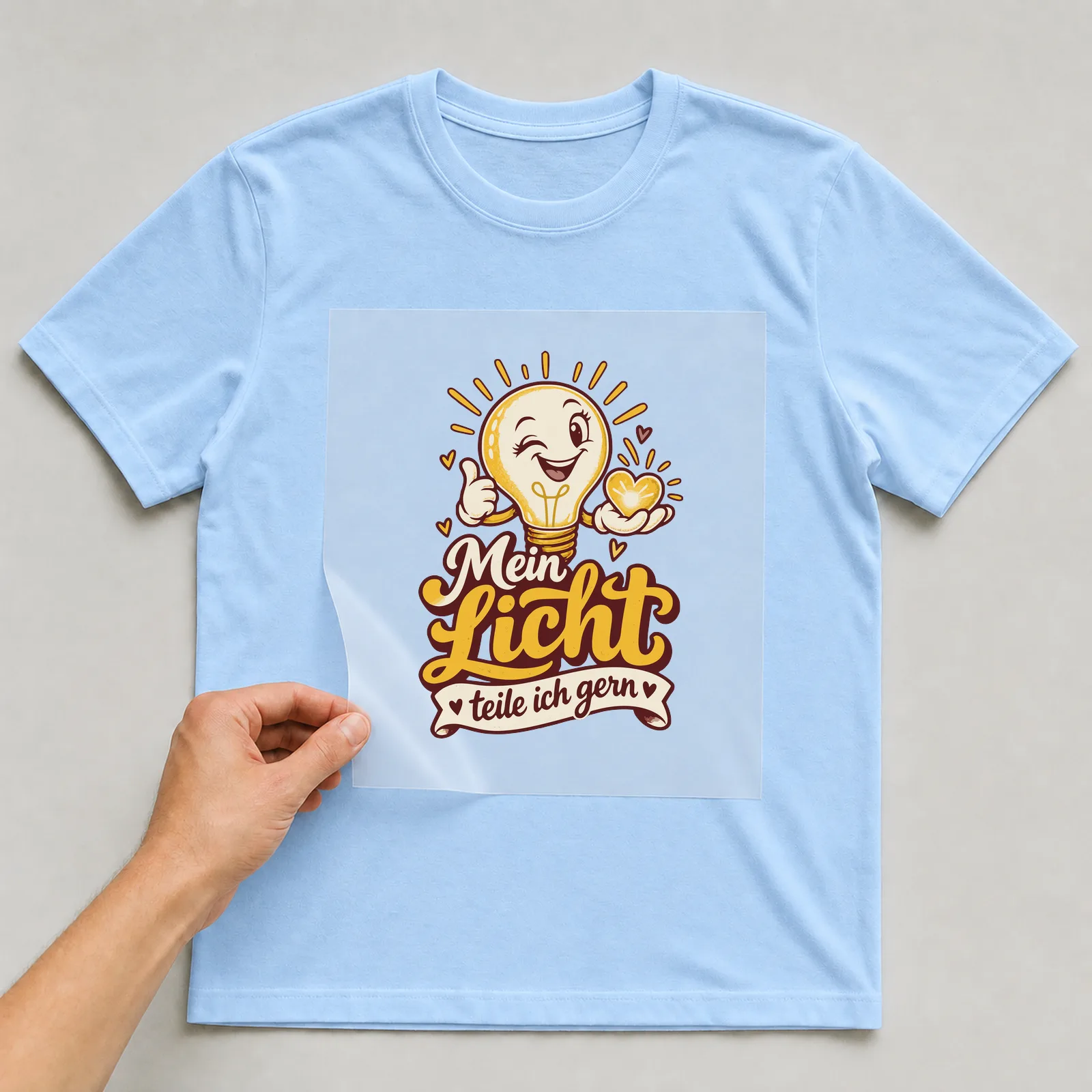 Bügelbild Mein Licht teile ich gern auf hellblauem T-Shirt, Folie wird aufgelegt