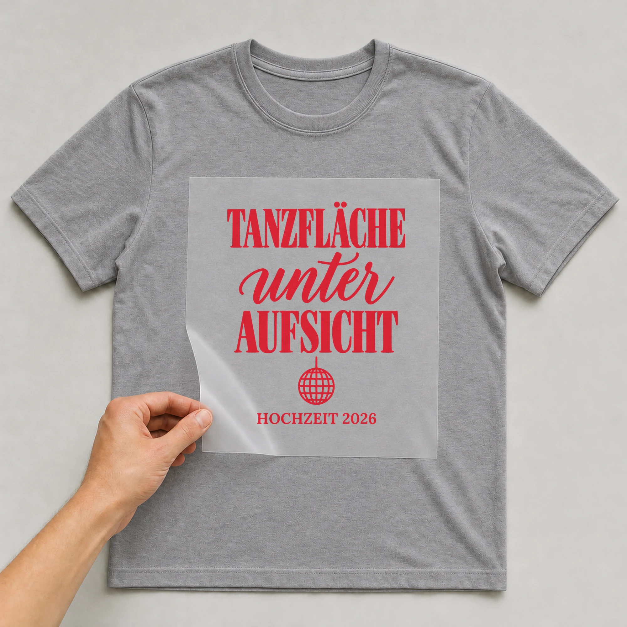 Bügelbild Tanzfläche unter Aufsicht mit Jahr auf grauem T-Shirt, Folie wird aufgelegt