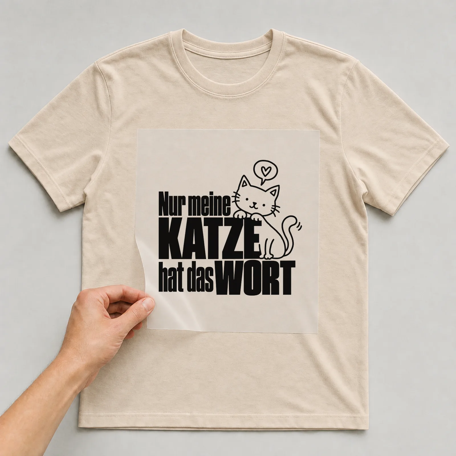 Bügelbild „Nur meine Katze hat das Wort“ auf beigem T-Shirt, Folie wird aufgelegt