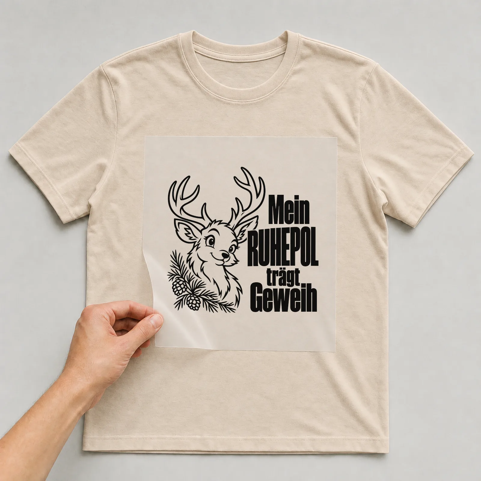 Bügelbild „Mein Ruhepol trägt Geweih“ auf beigem T-Shirt, Folie wird aufgelegt
