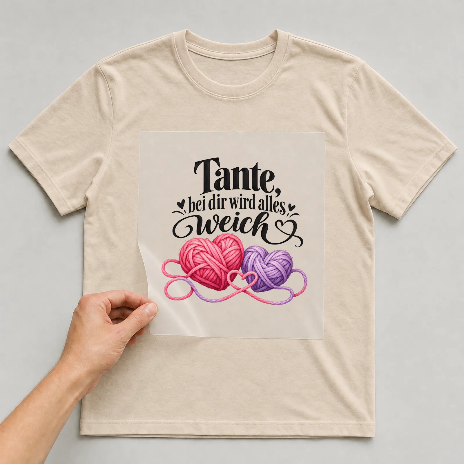 Bügelbild „Tante, bei dir wird alles weich“ auf beigem T-Shirt, Folie wird aufgelegt
