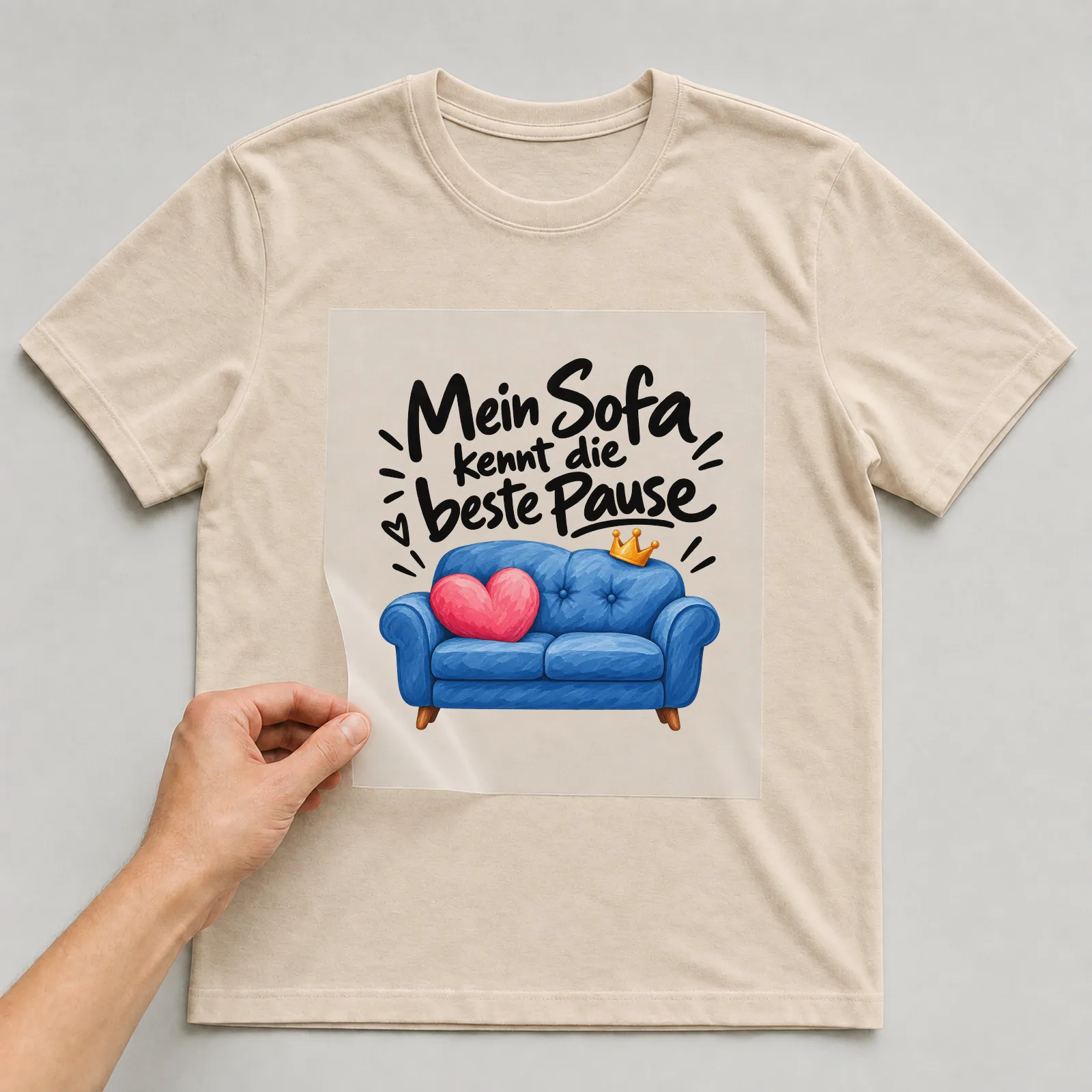 Bügelbild „Mein Sofa kennt die beste Pause“ auf beigem T-Shirt, Folie wird aufgelegt