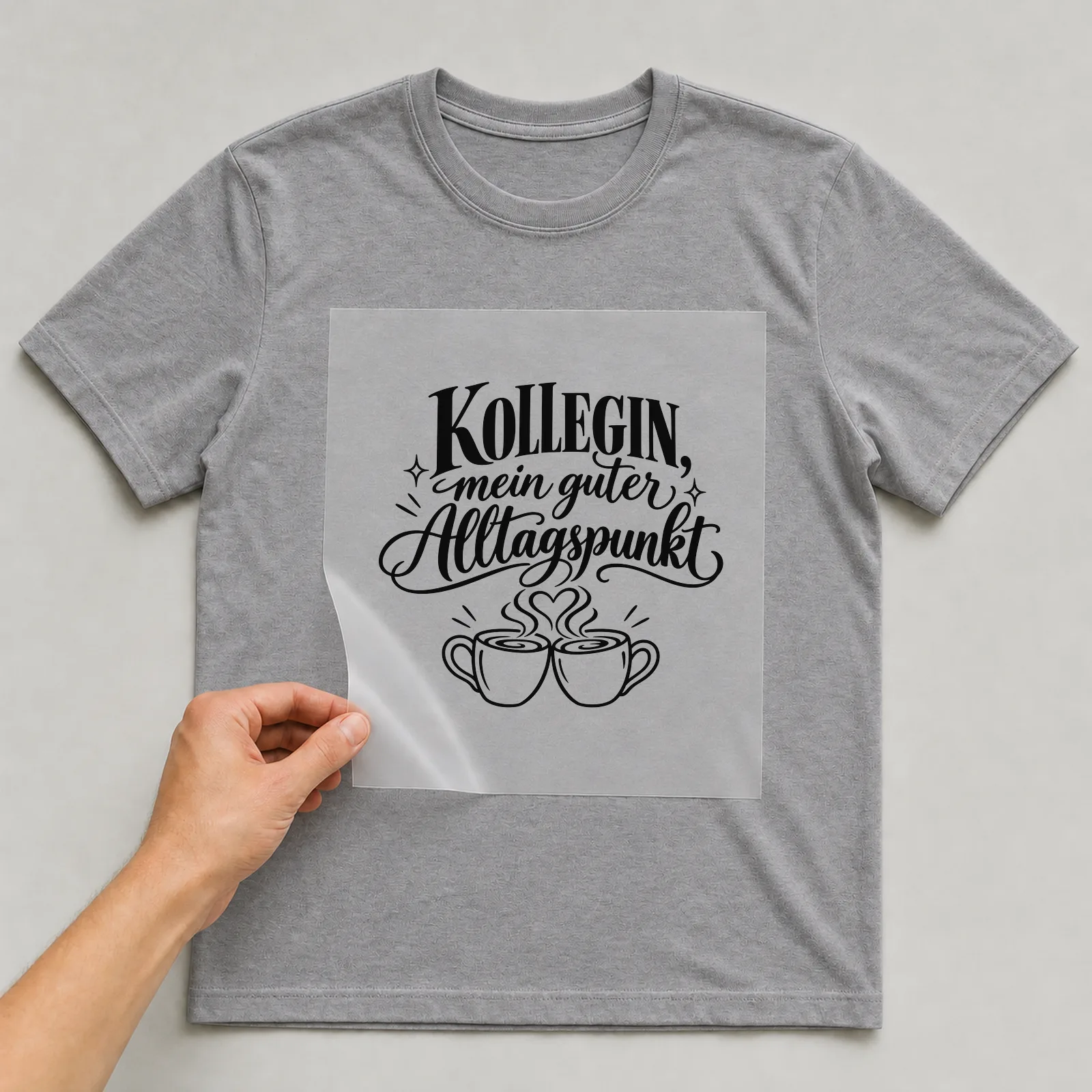 Bügelbild „Kollegin, mein guter Alltagspunkt“ auf grauem T-Shirt, Folie wird aufgelegt
