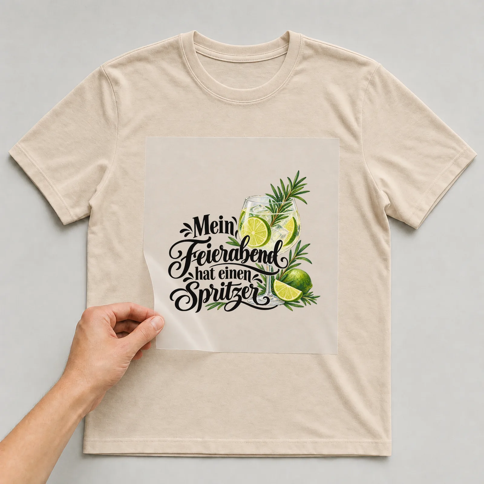 Bügelbild „Mein Feierabend hat einen Spritzer“ auf beigem T-Shirt, Folie wird aufgelegt