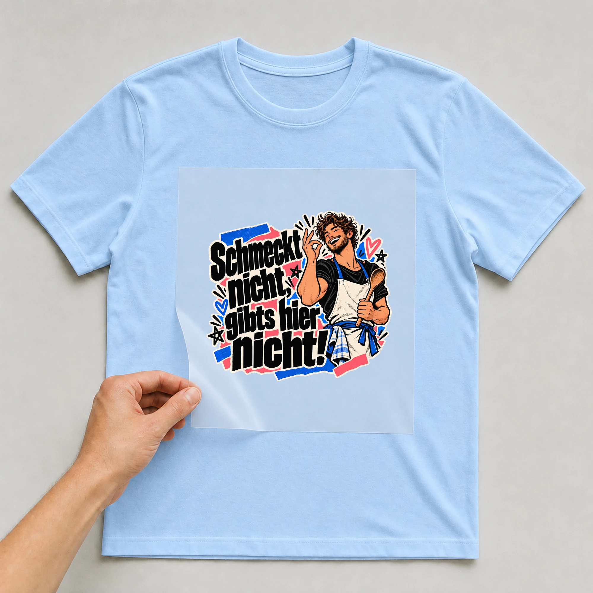 Bügelbild „Schmeckt nicht, gibts hier nicht!“ auf babyblauem T-Shirt, Folie wird aufgelegt