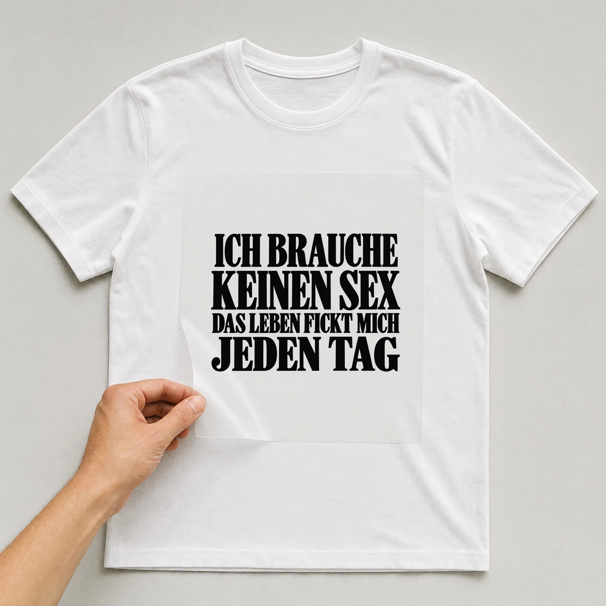 Bügelbild „Ich Brauche Keinen Sex Das Leben F**kt Mich Jeden Tag“ auf weißem T-Shirt, Folie wird aufgelegt