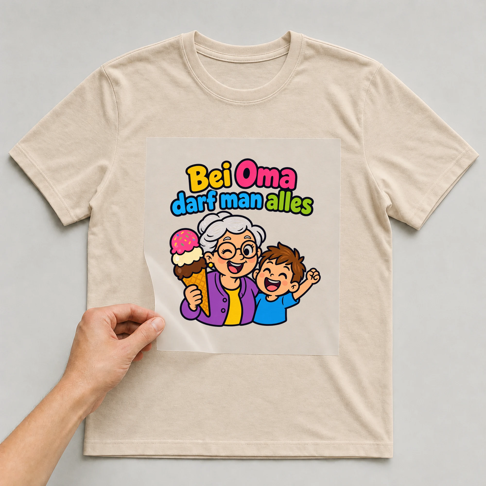 Bügelbild „Bei Oma darf man alles“ auf beigem T-Shirt, Folie wird aufgelegt