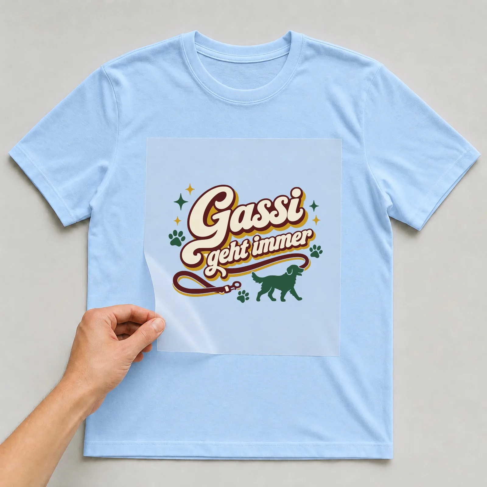 Bügelbild Gassi geht immer auf hellblauem T-Shirt, Folie wird aufgelegt