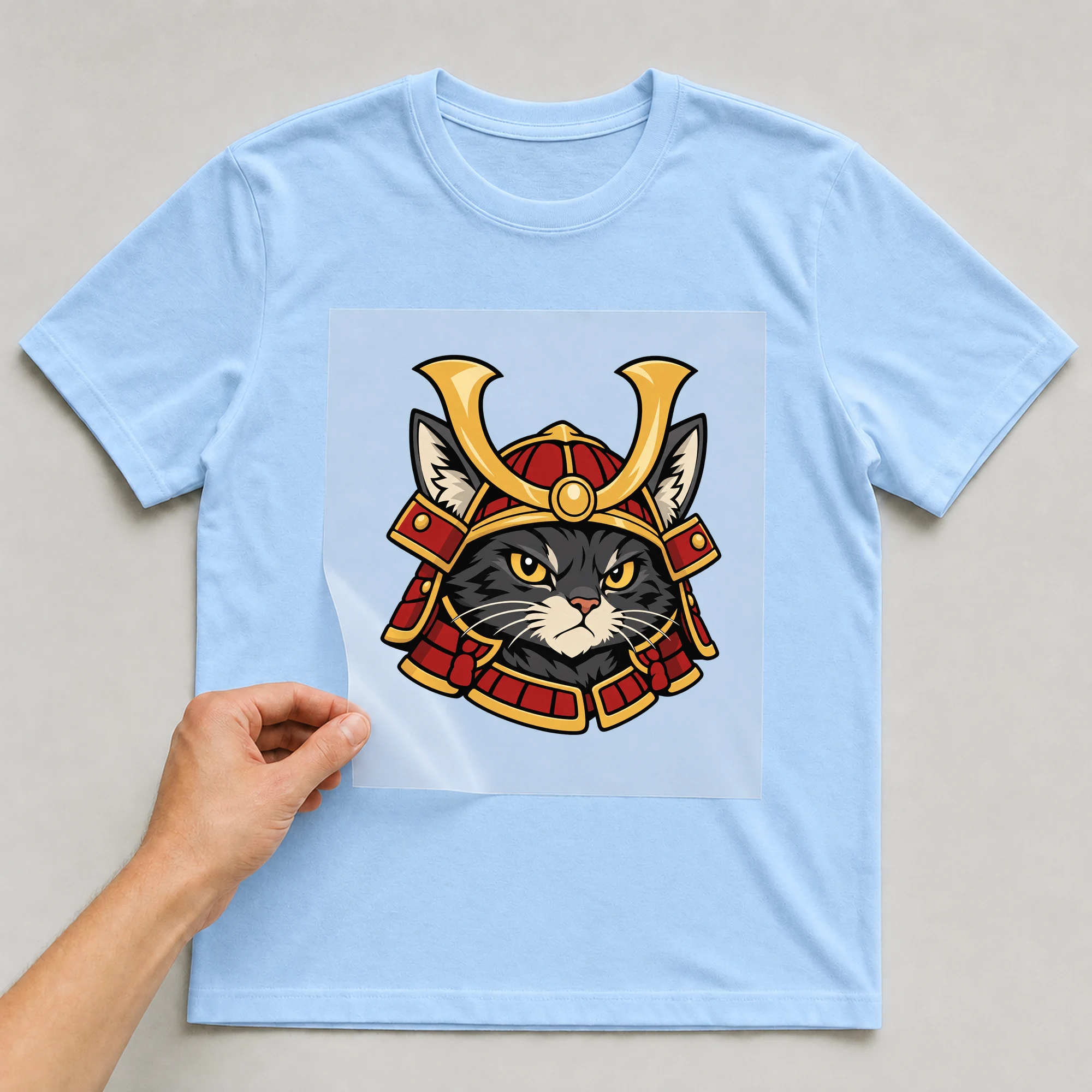 Bügelbild „Samurai Cat“ auf babyblauem T-Shirt, Folie wird aufgelegt