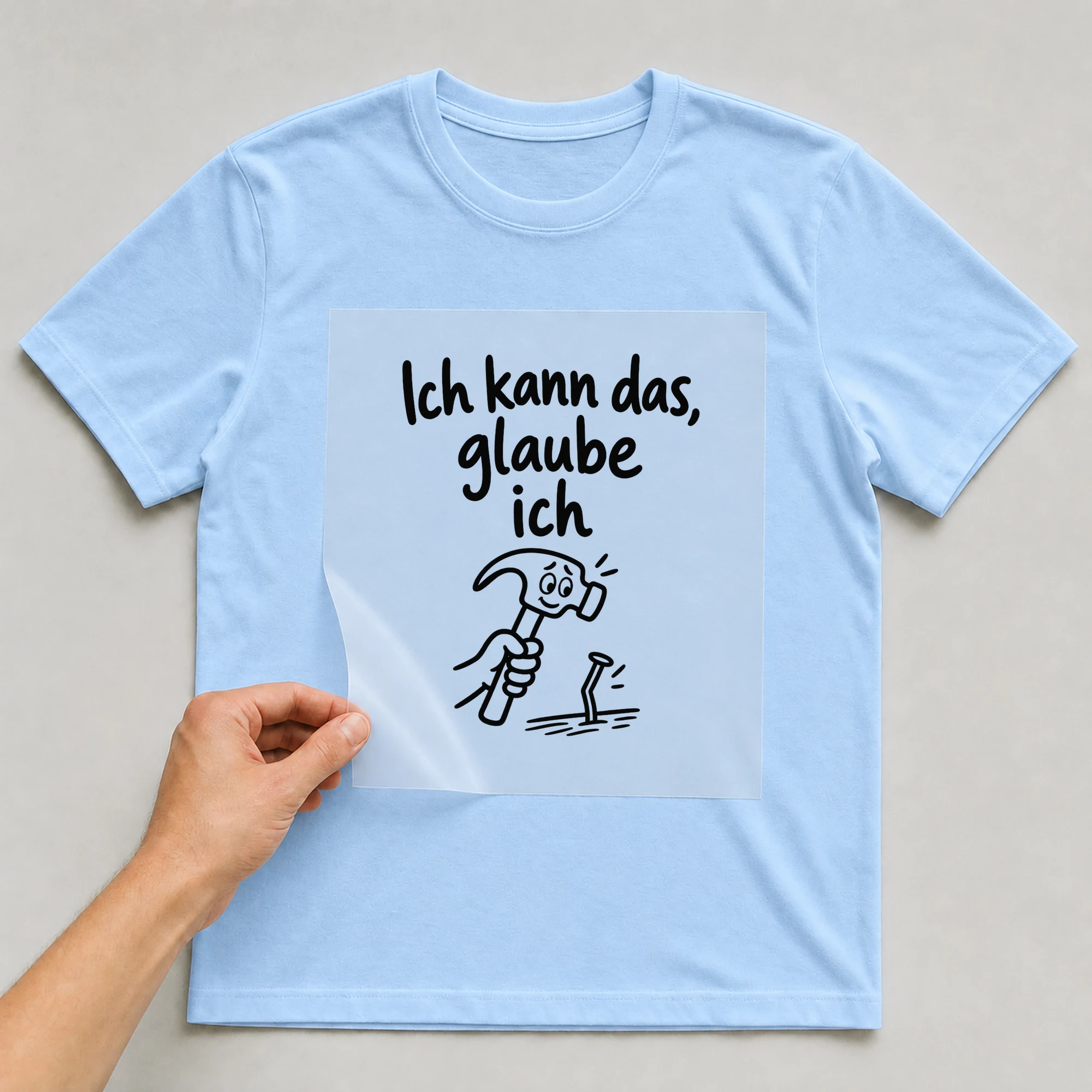 Bügelbild „Ich kann das, glaube ich“ auf babyblauem T-Shirt, Folie wird aufgelegt