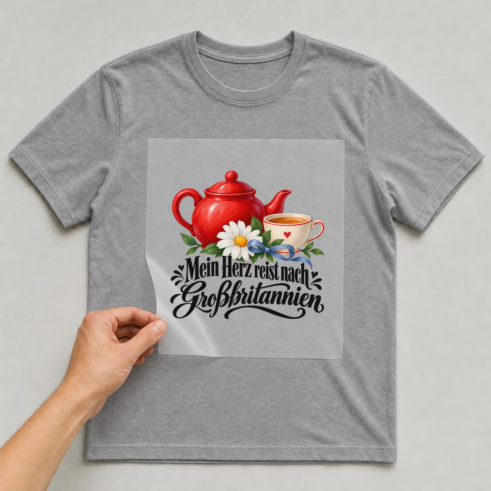 Bügelbild „Mein Herz reist nach Großbritannien“ auf grauem T-Shirt, Folie wird aufgelegt