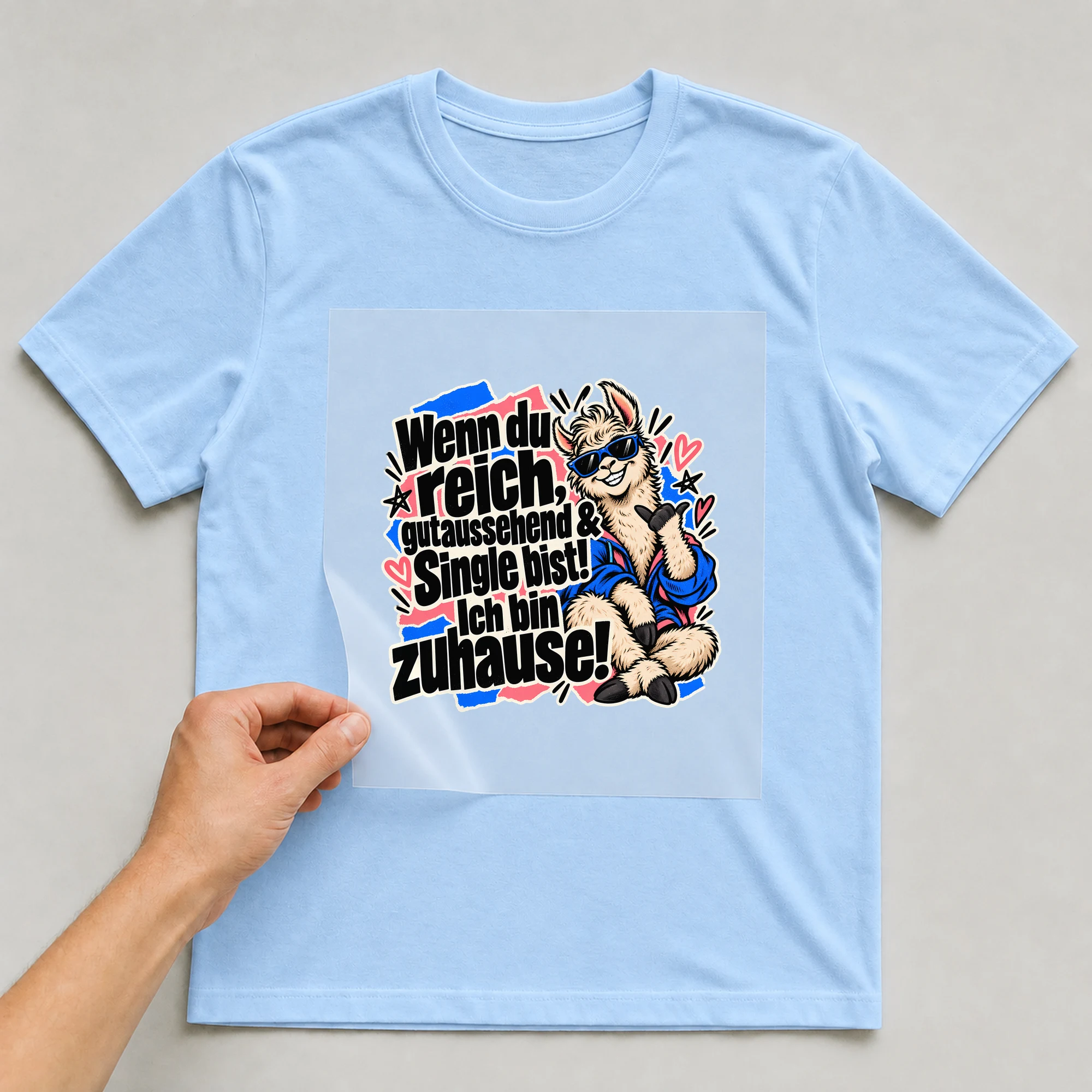 Bügelbild „Wenn du reich, gutaussehend & Single bist!“ auf babyblauem T-Shirt, Folie wird aufgelegt