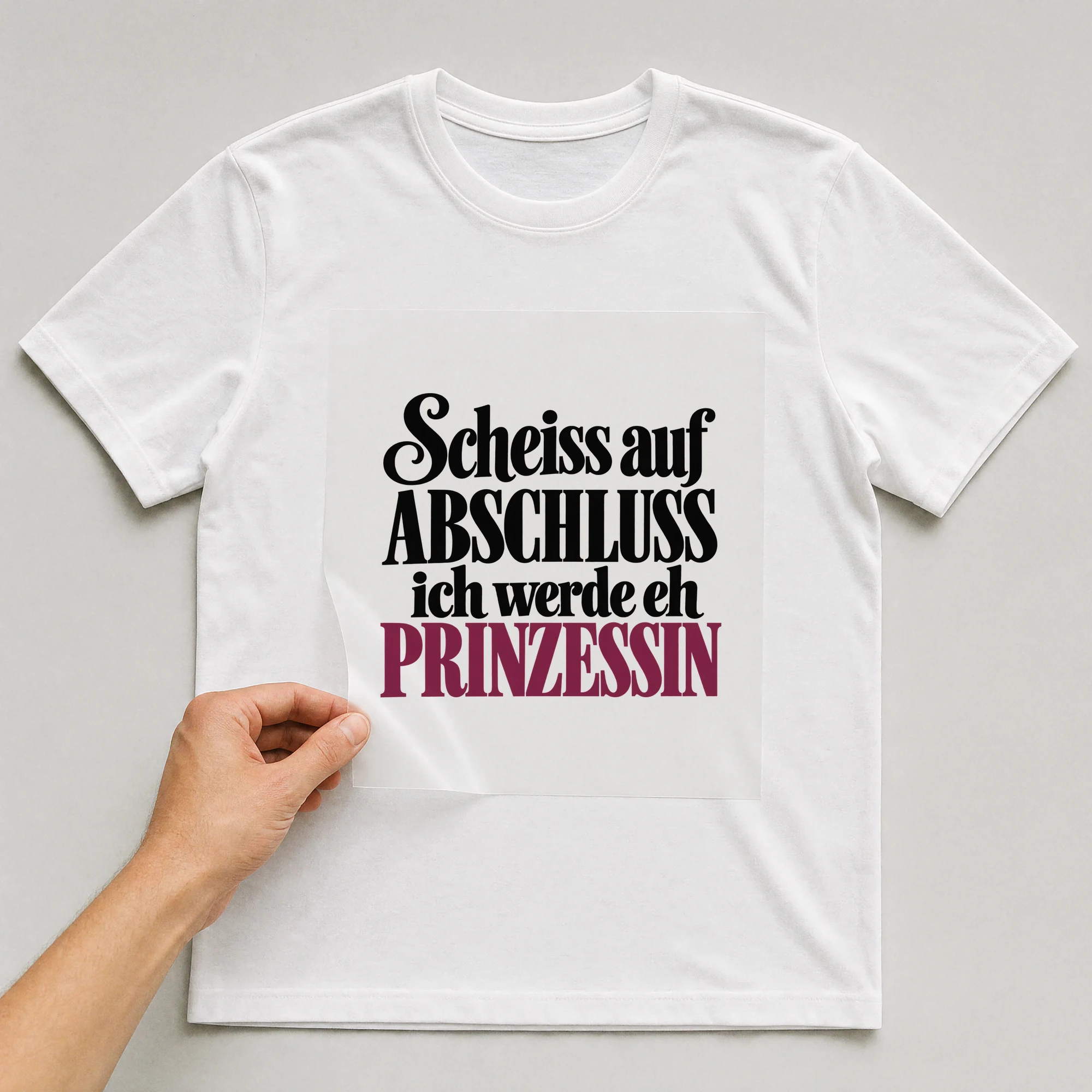 Bügelbild „Sch**ss auf Abschluss ich werde eh Prinzessin“ auf weißem T-Shirt, Folie wird aufgelegt
