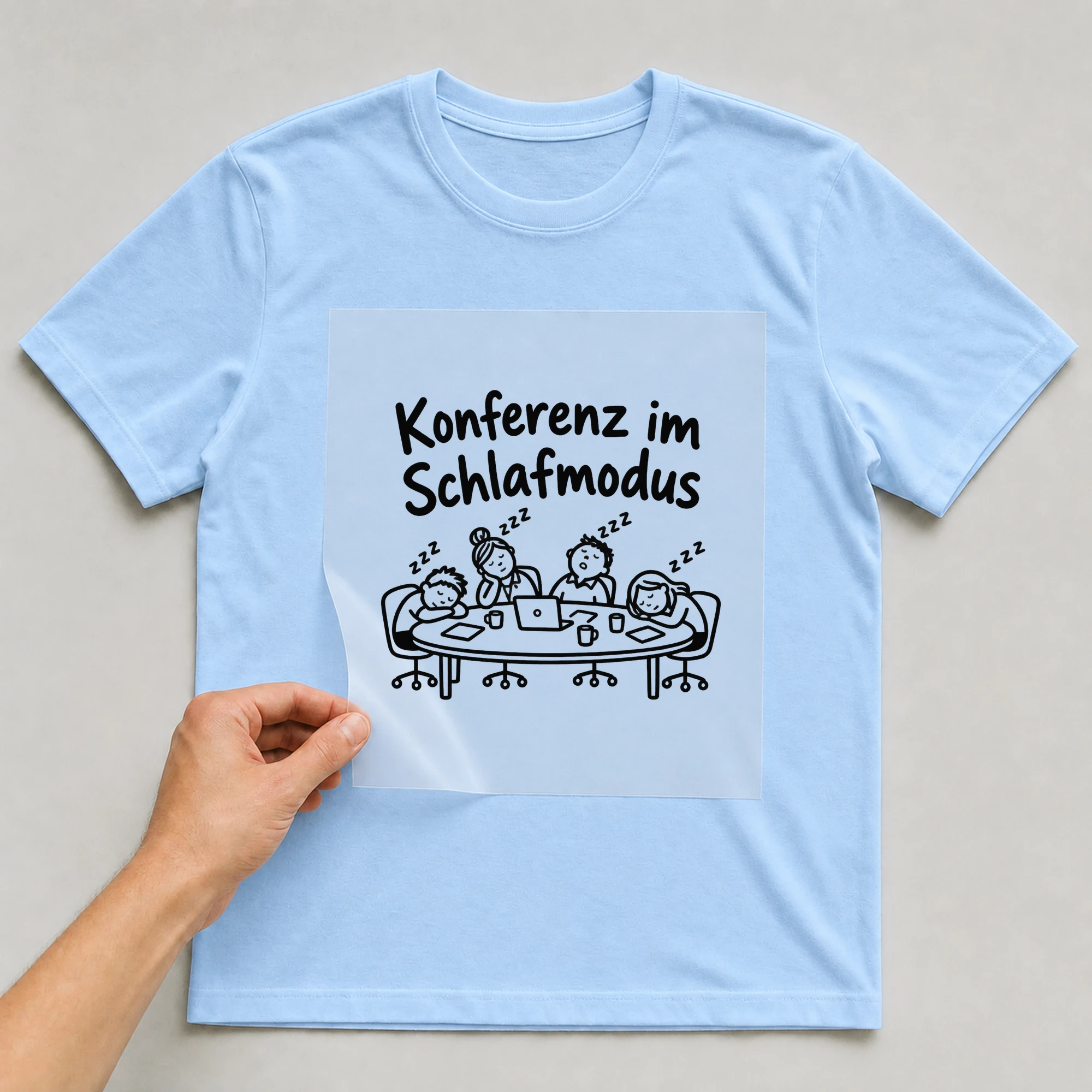 Bügelbild „Konferenz im Schlafmodus“ auf babyblauem T-Shirt, Folie wird aufgelegt