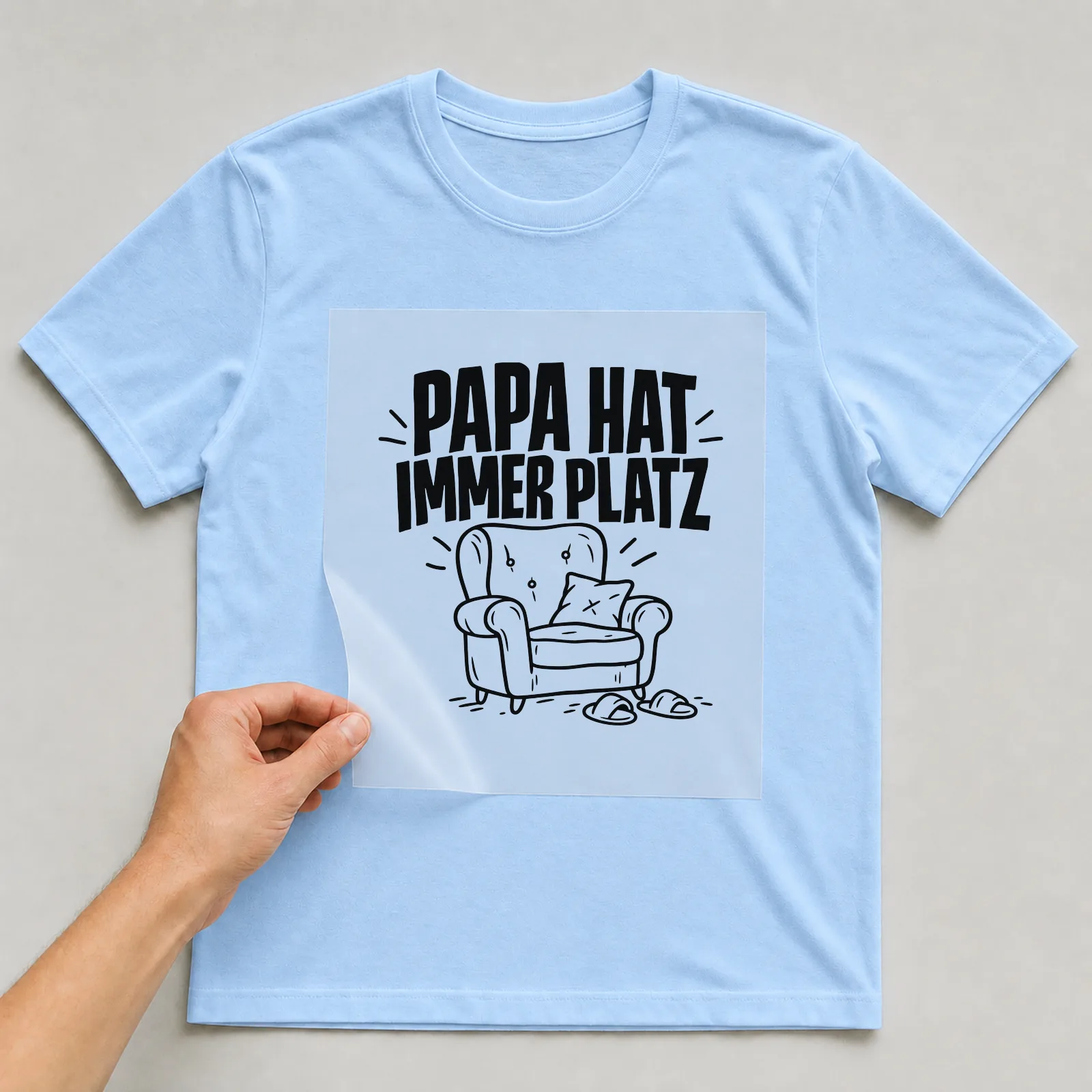 Bügelbild „Papa hat immer Platz“ auf hellblauem T-Shirt, Folie wird aufgelegt