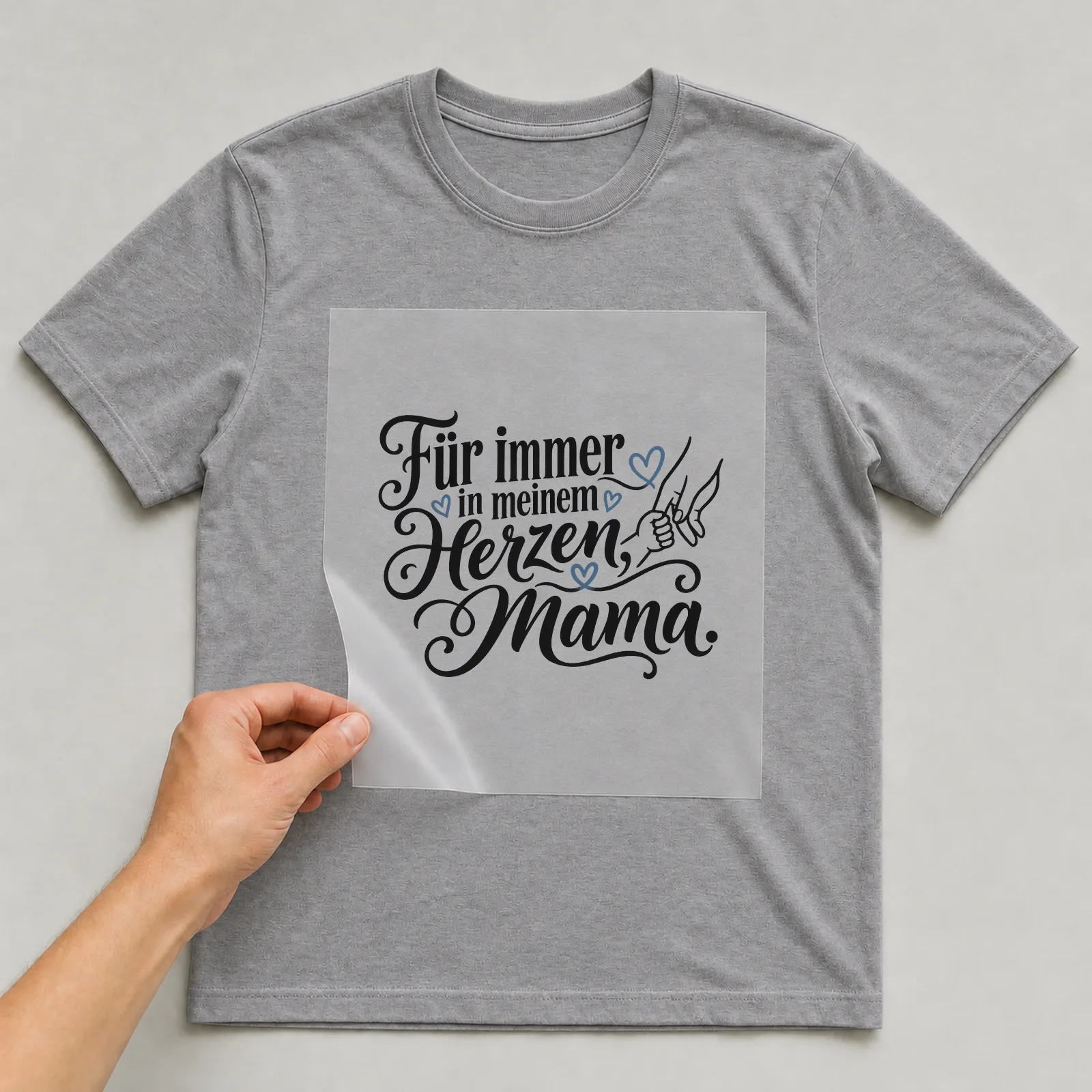 Bügelbild „Für immer in meinem Herzen, Mama“ auf grauem T-Shirt, Folie wird aufgelegt