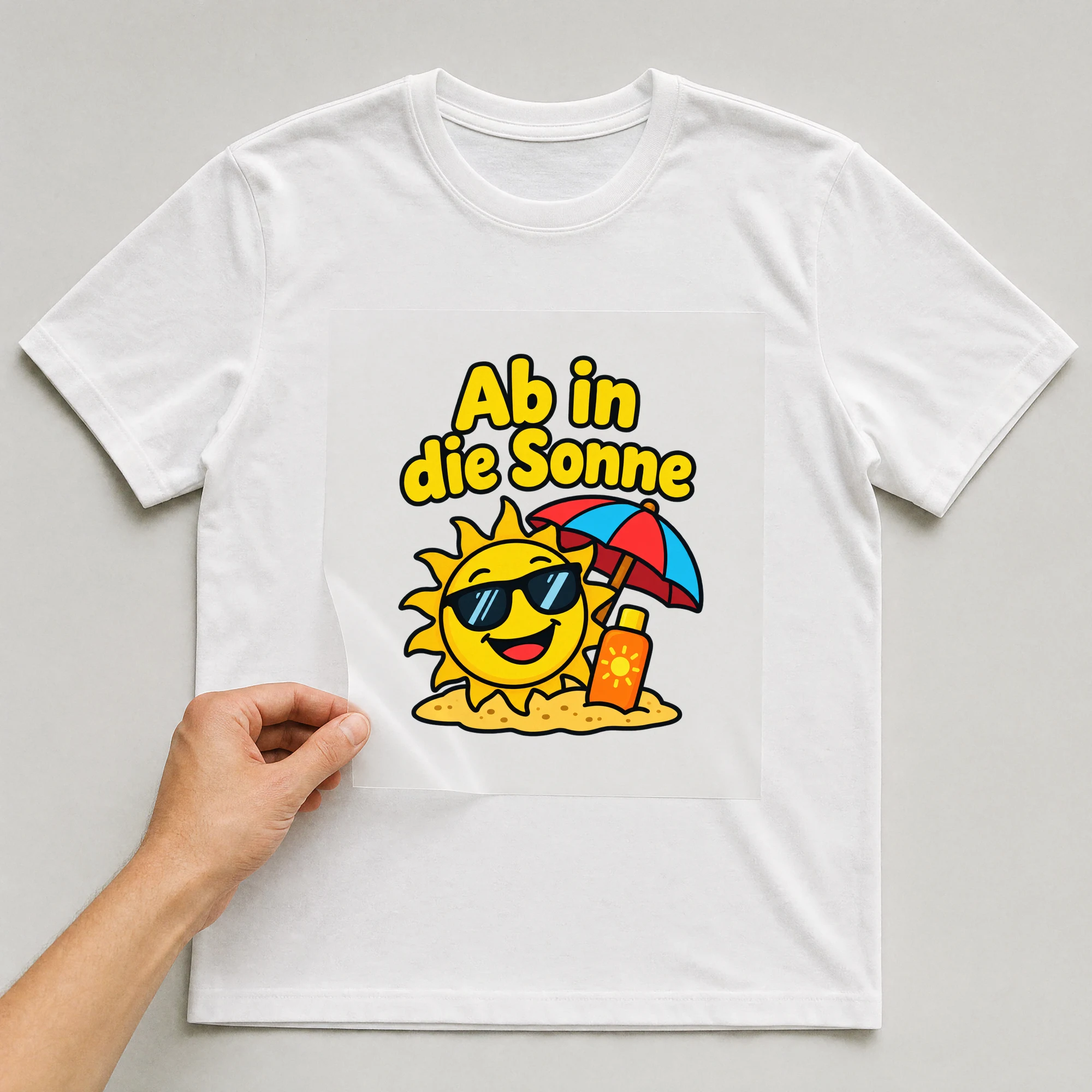 Bügelbild „Ab in die Sonne“ auf weißem T-Shirt, Folie wird aufgelegt