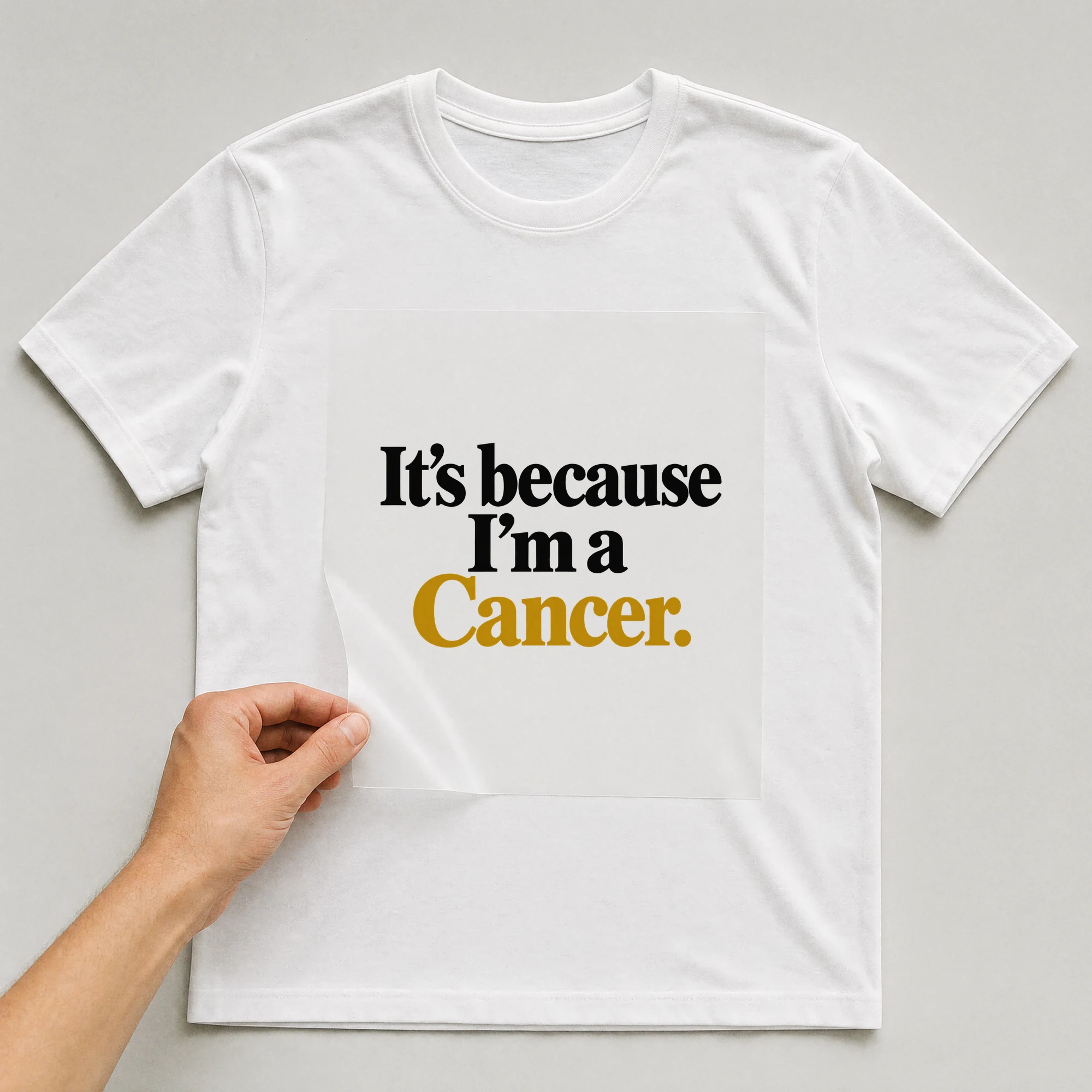 Bügelbild „It's because I'm a Cancer.“ auf weißem T-Shirt, Folie wird aufgelegt