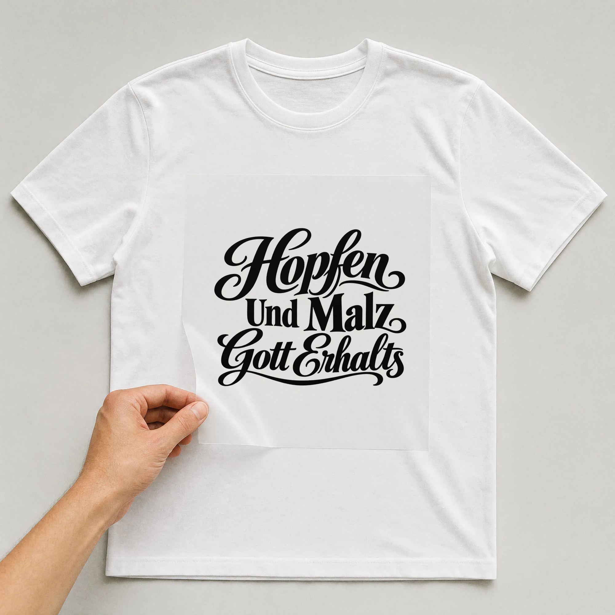 Bügelbild „Hopfen und Malz Gott erhalts“ auf weißem T-Shirt, Folie wird aufgelegt