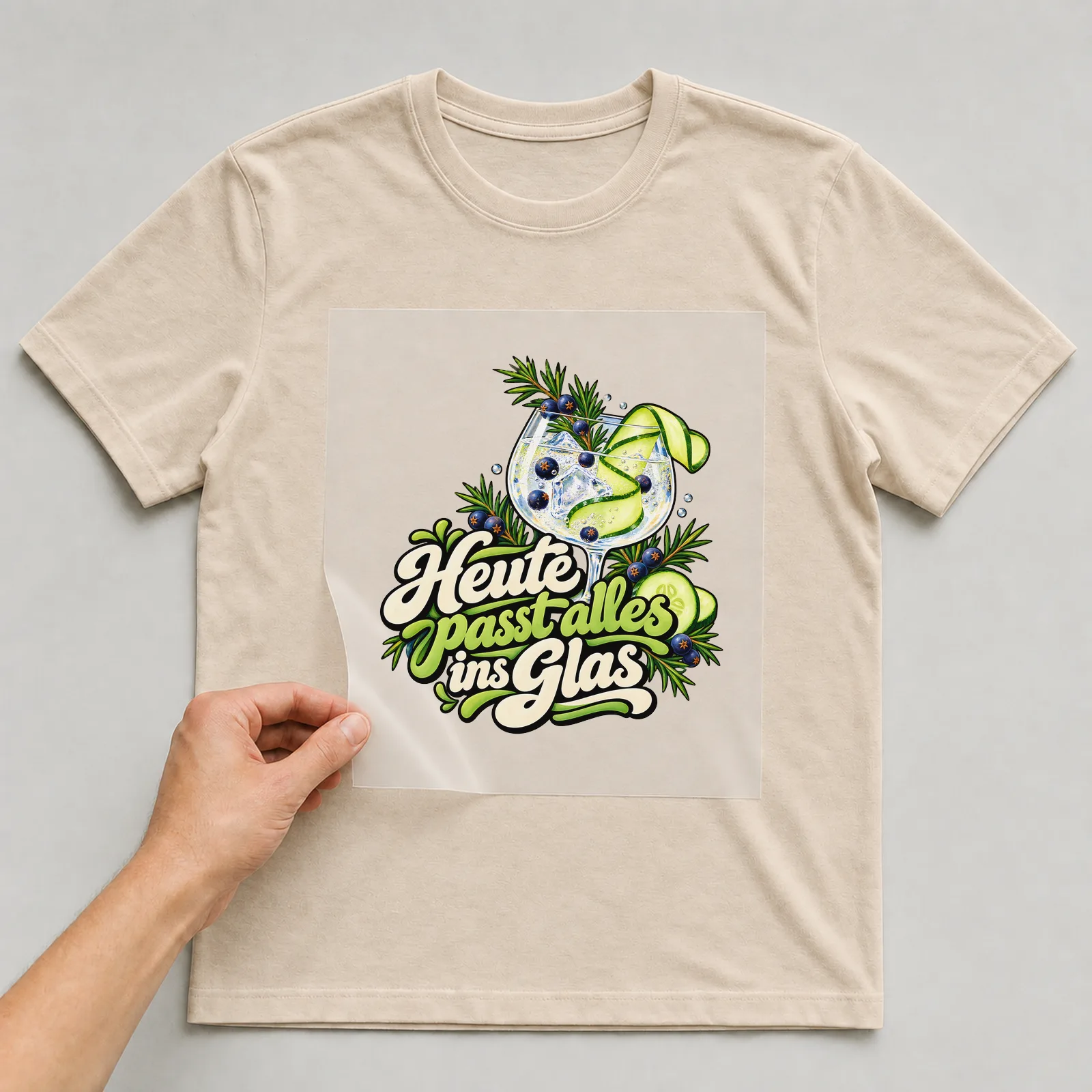 Bügelbild „Heute passt alles ins Glas“ auf beigem T-Shirt, Folie wird aufgelegt