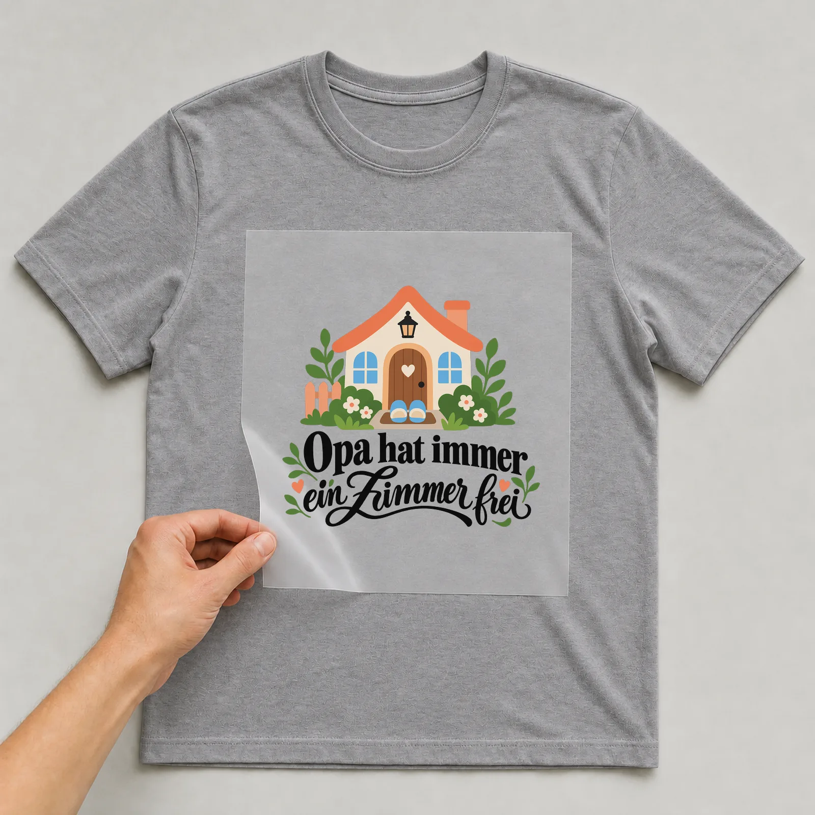 Bügelbild „Opa hat immer ein Zimmer frei“ auf grauem T-Shirt, Folie wird aufgelegt