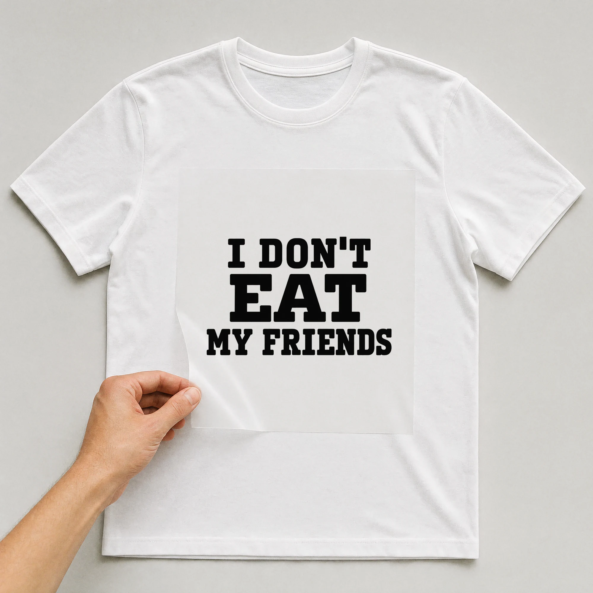 Bügelbild „I DON'T EAT MY FRIENDS“ auf weißem T-Shirt, Folie wird aufgelegt