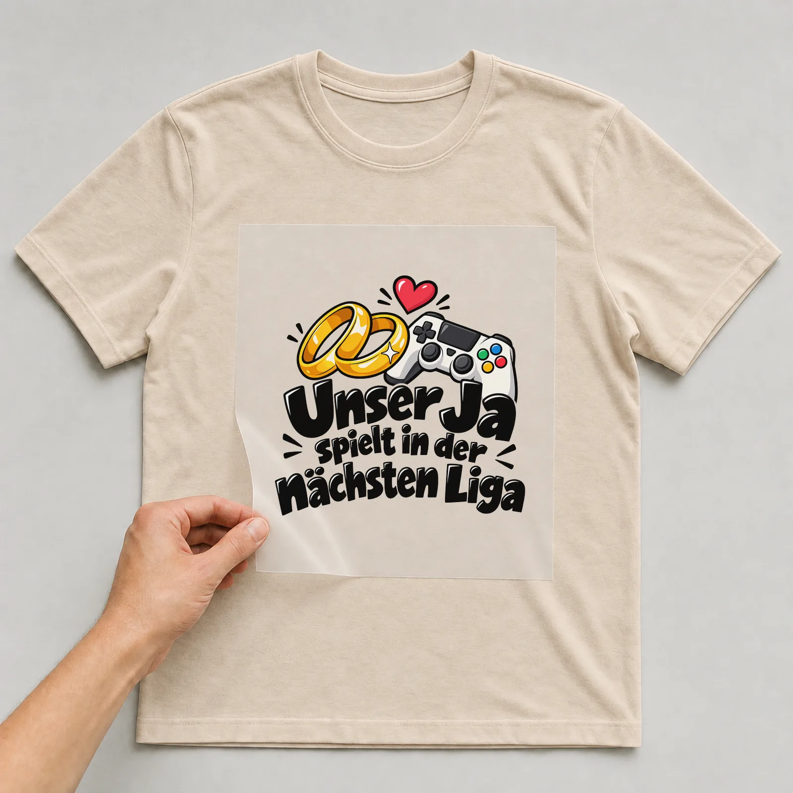 Bügelbild „Unser Ja spielt in der nächsten Liga“ auf beigem T-Shirt, Folie wird aufgelegt