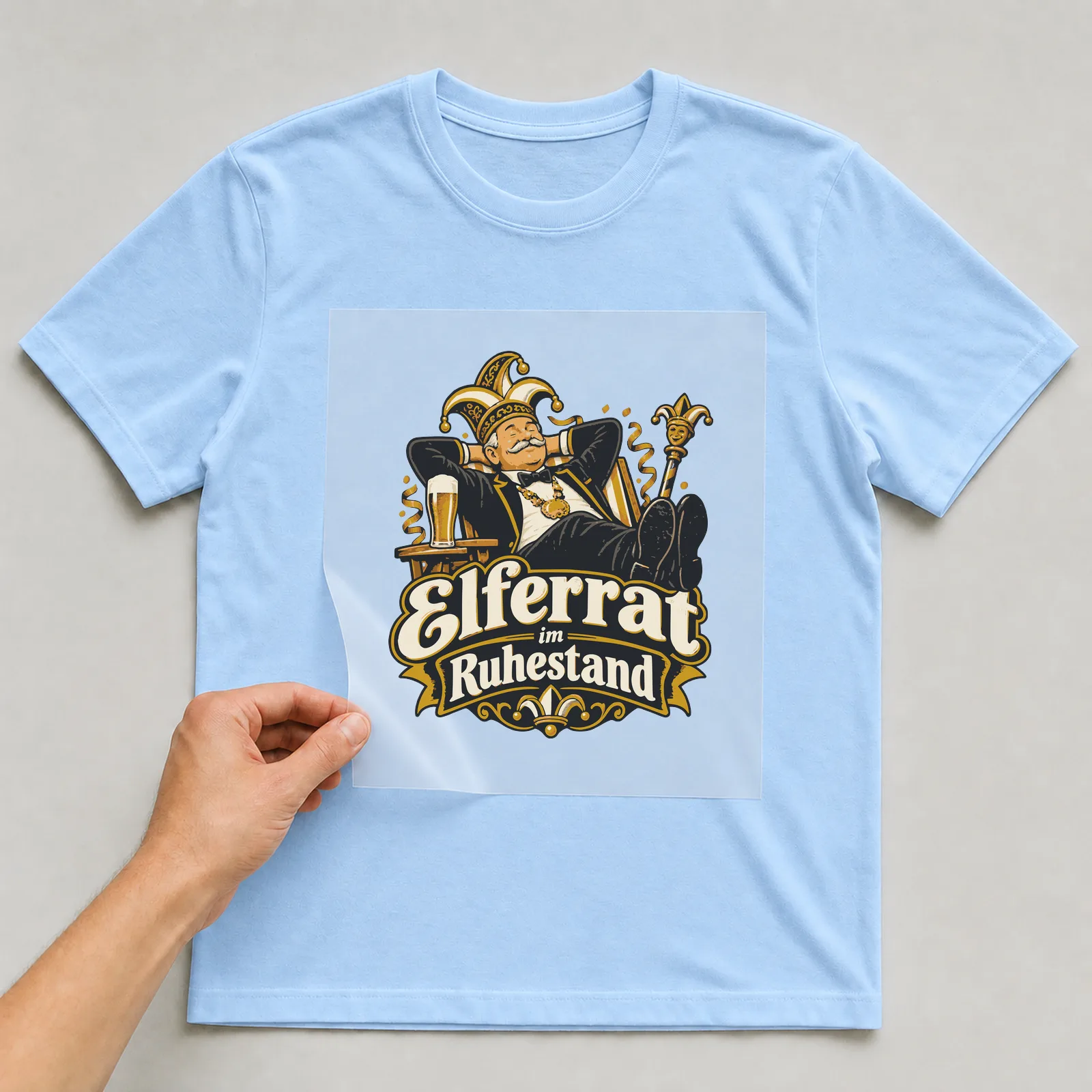 Bügelbild Elferrat im Ruhestand auf hellblauem T-Shirt, Folie wird aufgelegt