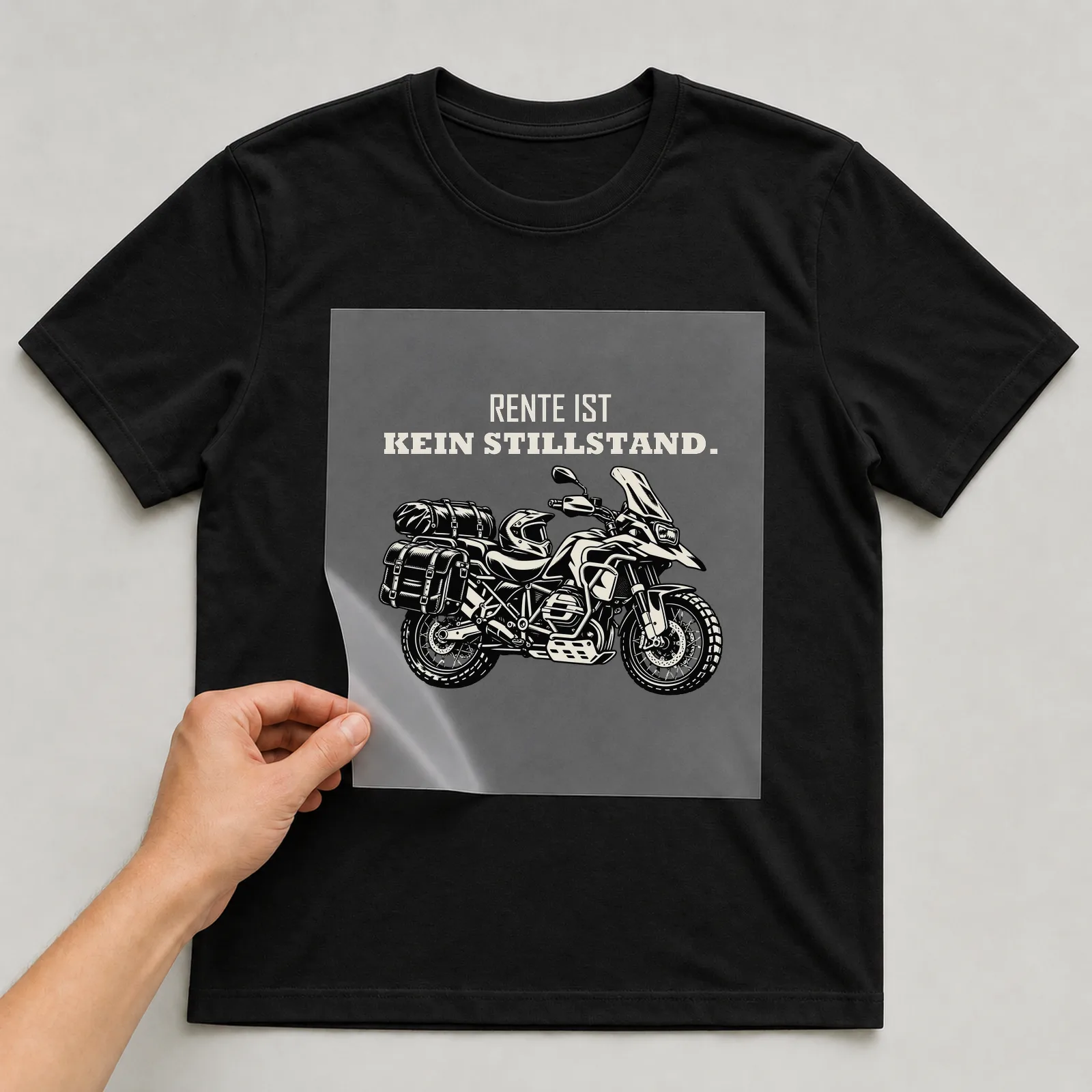 Bügelbild „Rente ist kein Stillstand“ auf schwarzem T-Shirt, Folie wird aufgelegt