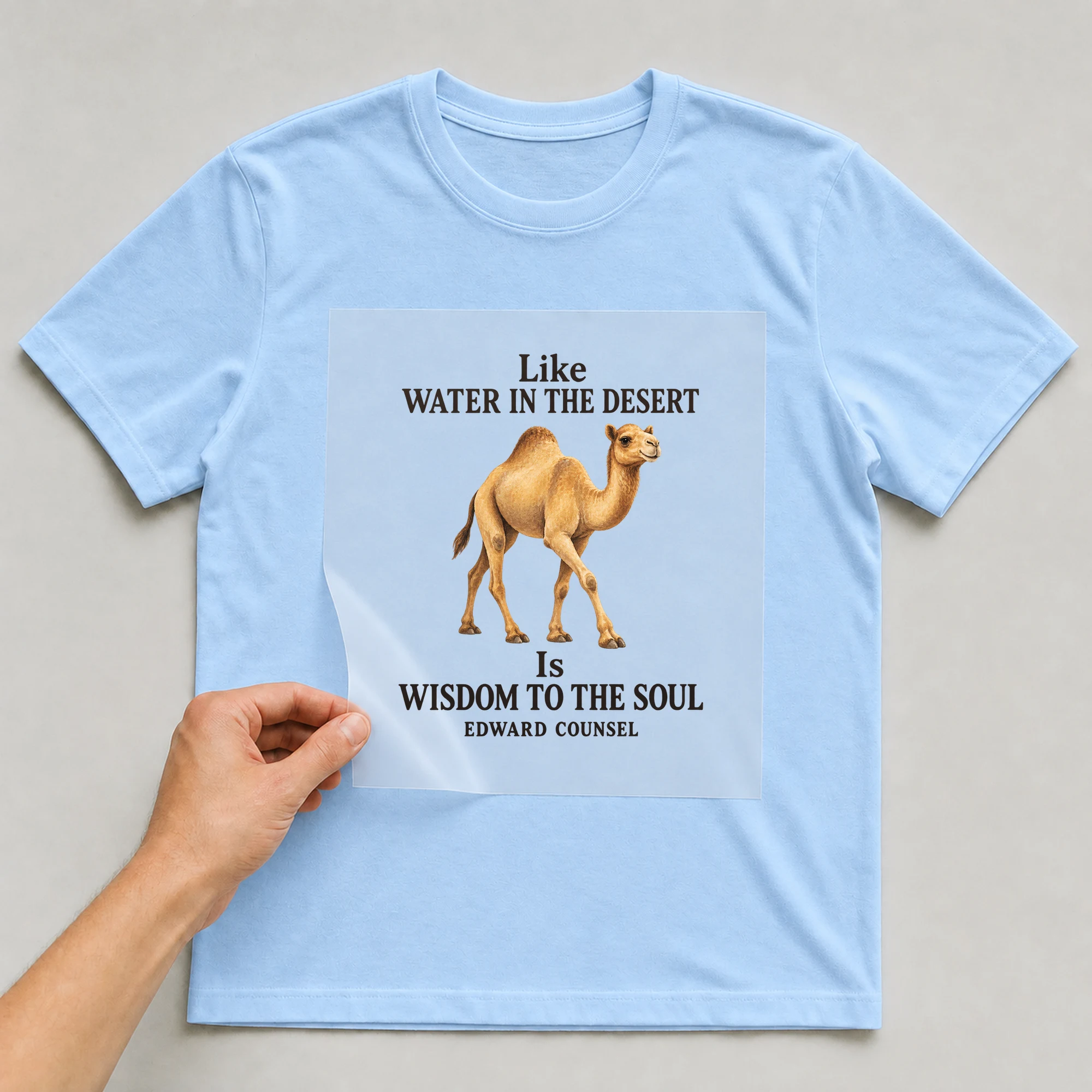 Bügelbild „Like WATER IN THE DESERT Is WISDOM TO THE SOUL EDWARD COUNSEL“ auf babyblauem T-Shirt, Folie wird aufgelegt
