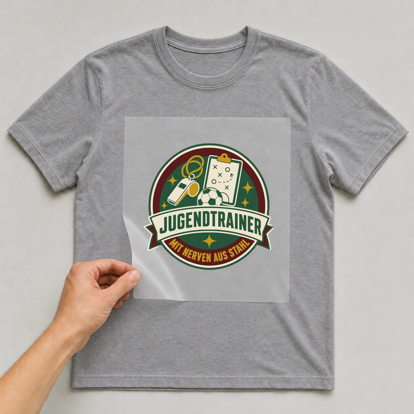 Bügelbild Jugendtrainer mit Nerven aus Stahl auf grauem T-Shirt, Folie wird aufgelegt