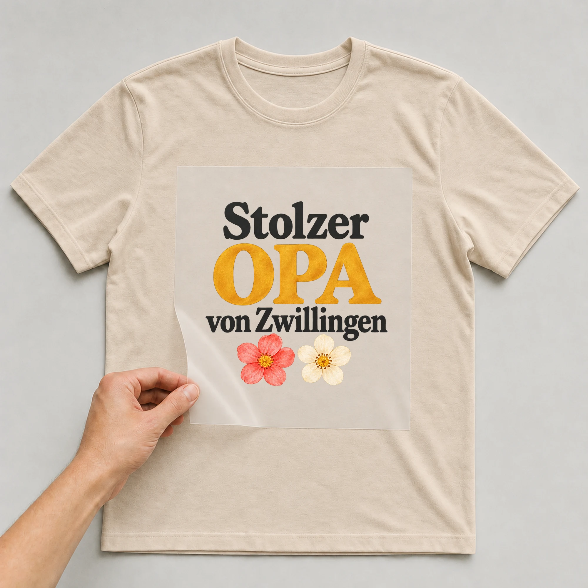 Bügelbild „Stolzer OPA von Zwillingen“ auf beigem T-Shirt, Folie wird aufgelegt