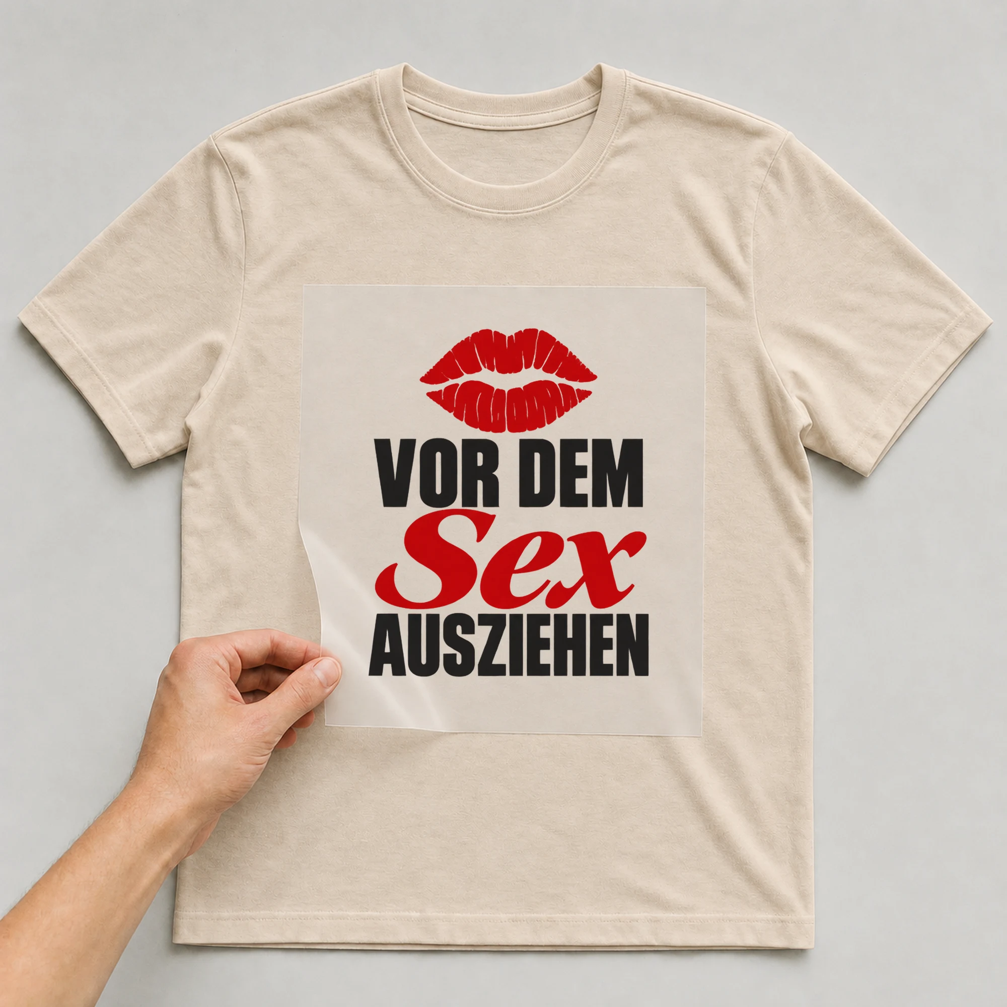 Bügelbild „Vor dem Sex ausziehen“ auf beigem T-Shirt, Folie wird aufgelegt