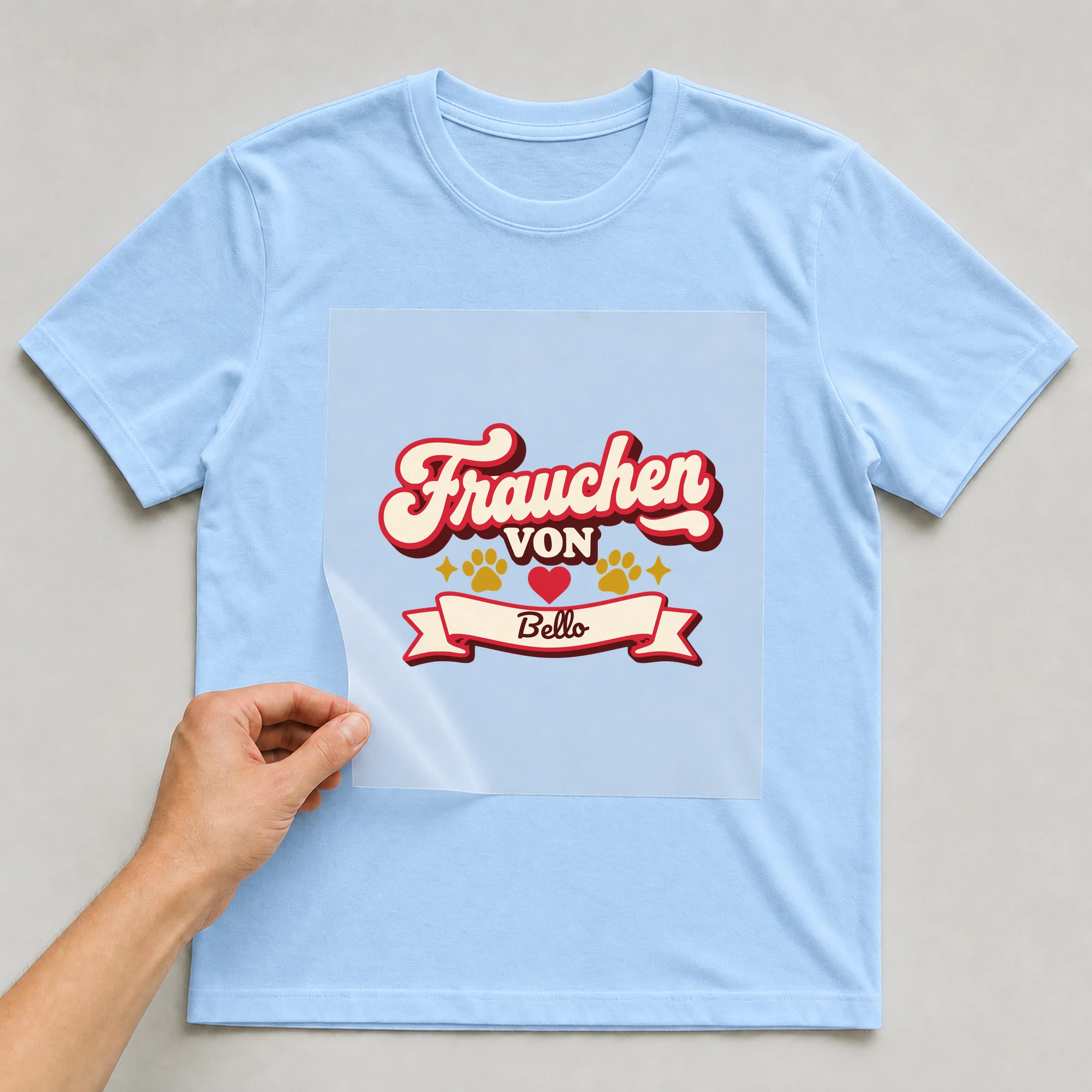 Bügelbild Frauchen mit Name auf hellblauem T-Shirt, Folie wird aufgelegt