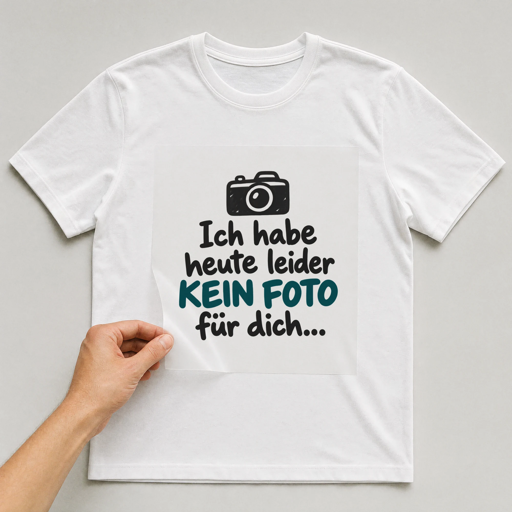 Bügelbild „Ich habe heute leider kein Foto für dich...“ auf weißem T-Shirt, Folie wird aufgelegt