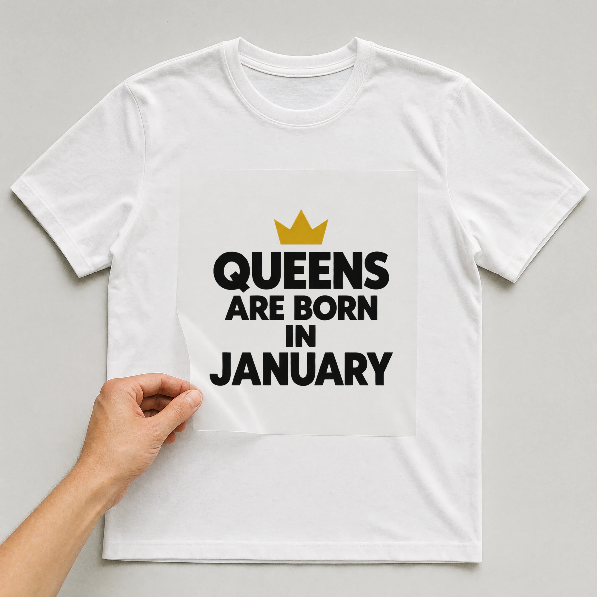 Bügelbild „QUEENS ARE BORN IN JANUARY“ auf weißem T-Shirt, Folie wird aufgelegt