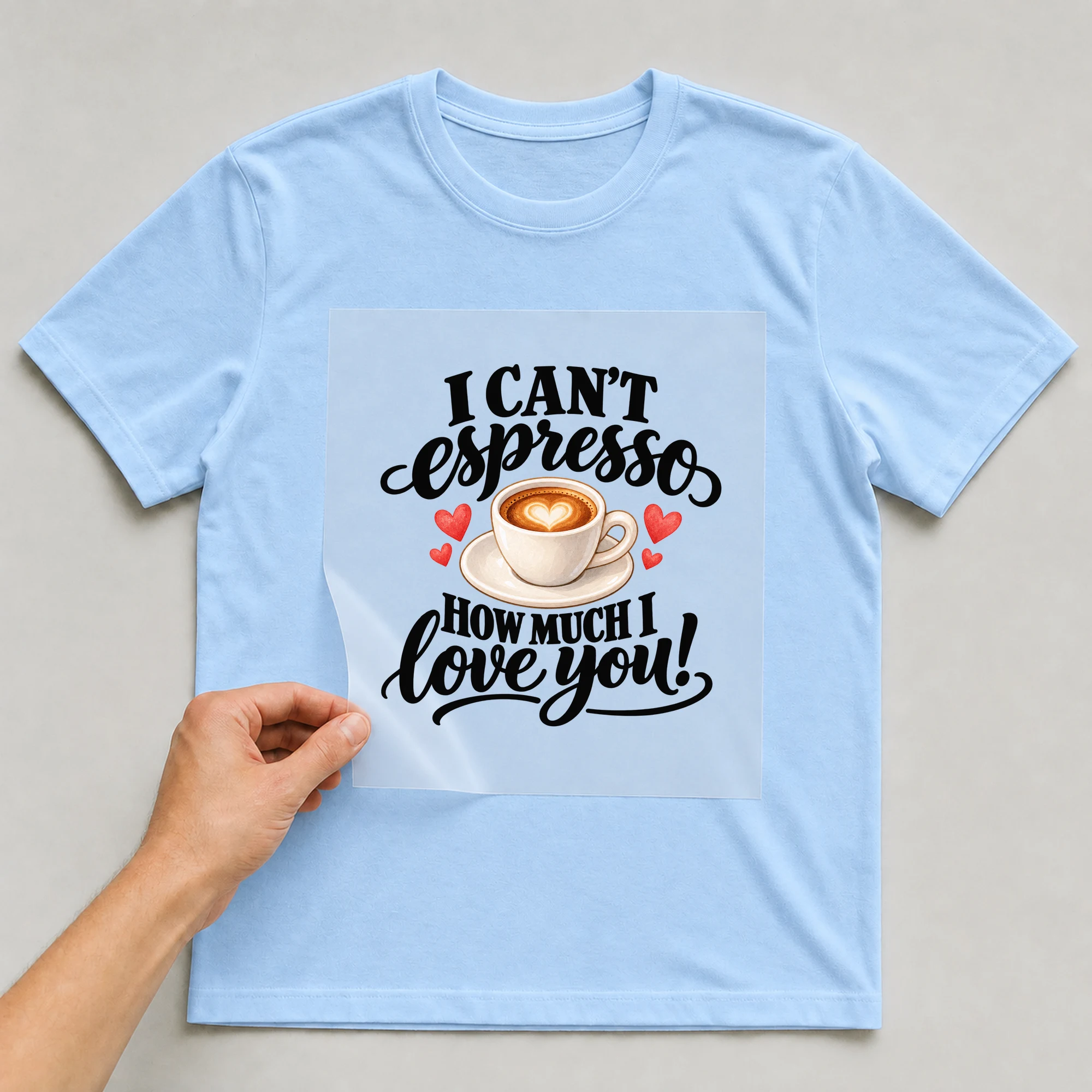 Bügelbild „I Can't Espresso How Much I Love You!“ auf babyblauem T-Shirt, Folie wird aufgelegt