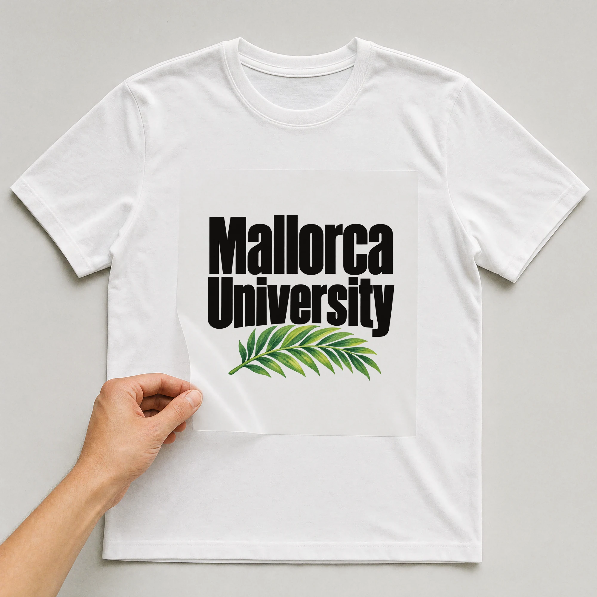 Bügelbild „Mallorca University“ auf weißem T-Shirt, Folie wird aufgelegt