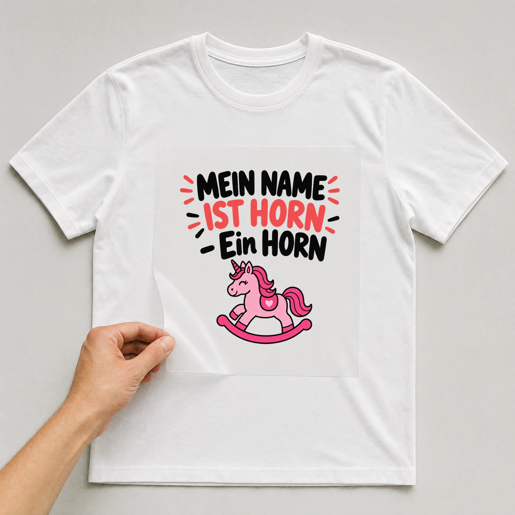 Bügelbild „Mein Name ist Horn - Ein Horn“ auf weißem T-Shirt, Folie wird aufgelegt